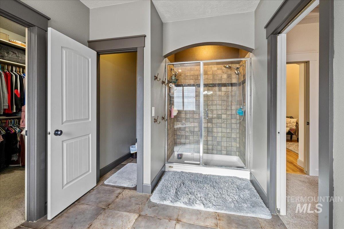 Full bath featuring a walk in closet and a shower stall