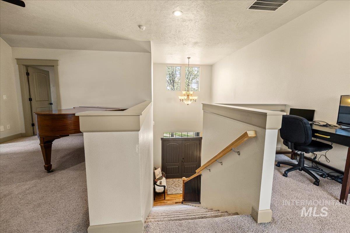 Office area featuring carpet flooring, a textured ceiling, and a chandelier