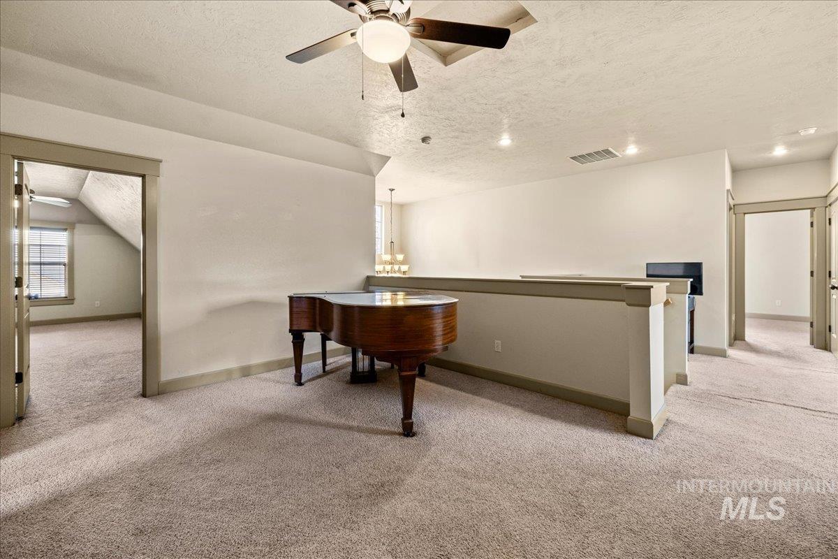 Office with a textured ceiling, light carpet, plenty of natural light, and ceiling fan