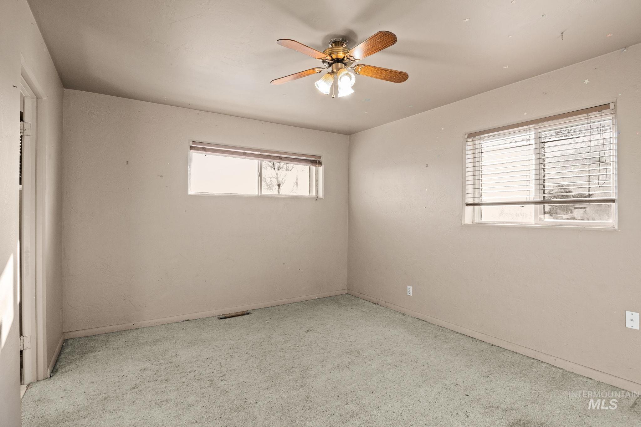 Spare room featuring ceiling fan and baseboards