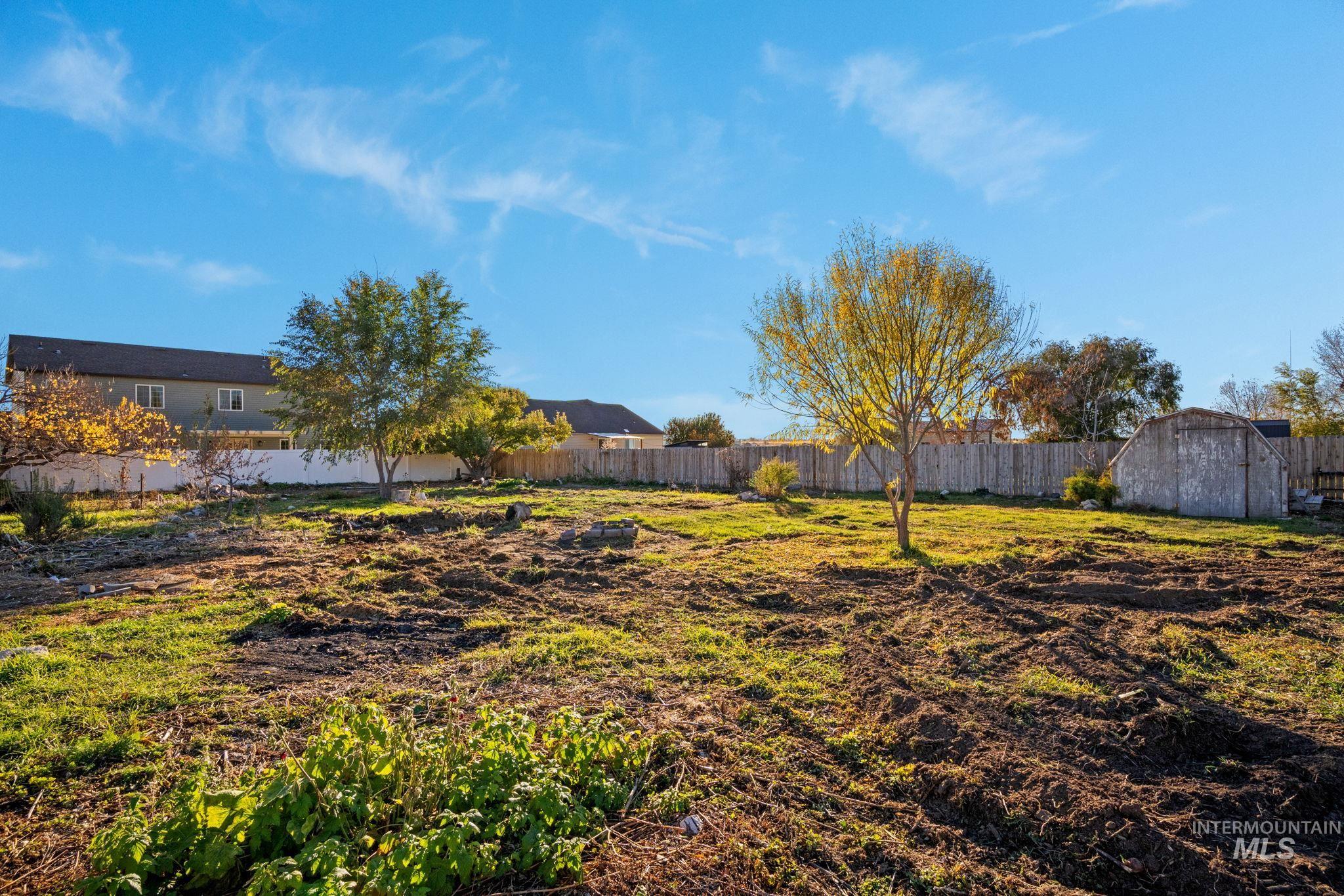 Fenced backyard featuring a shed
