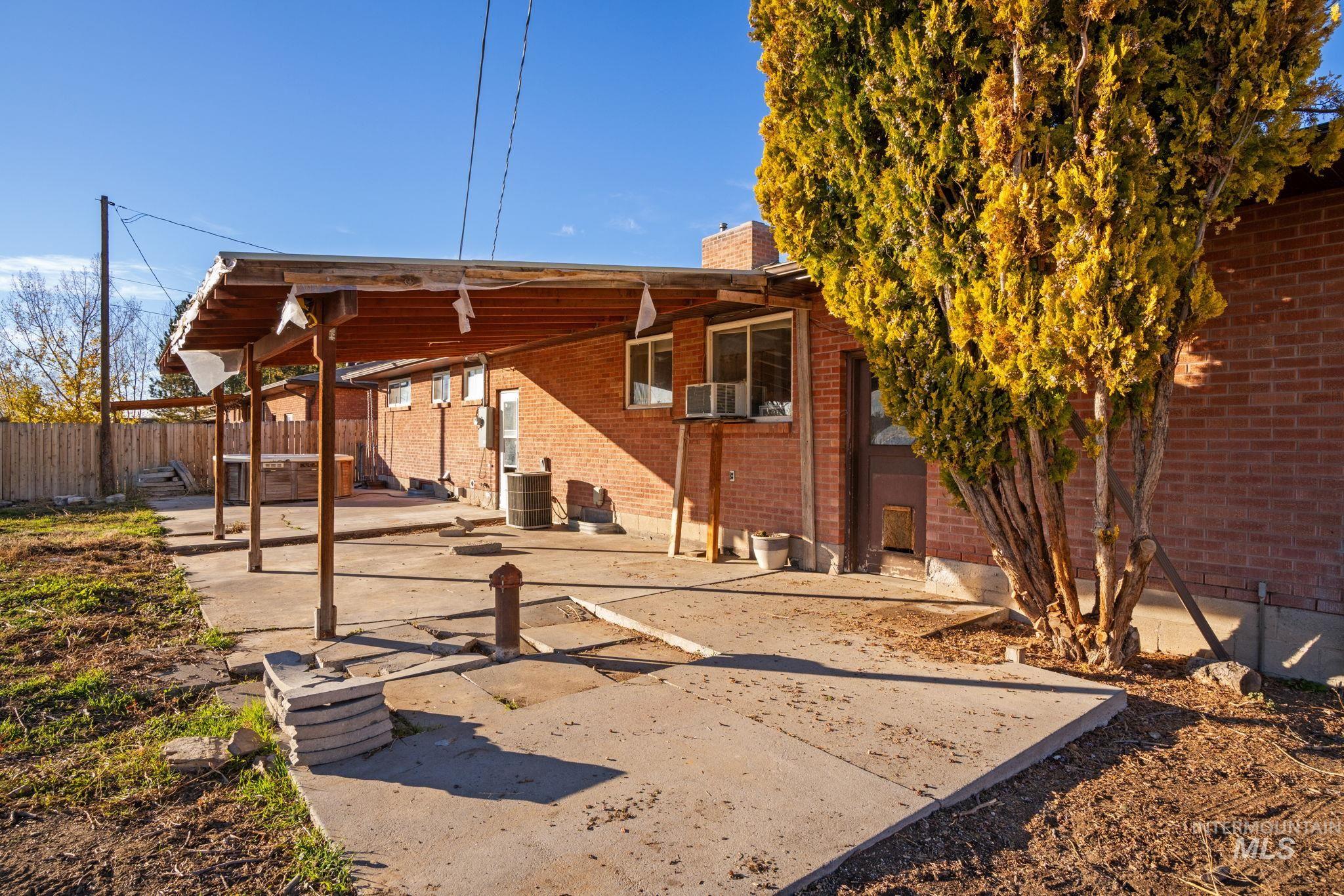 Rear view of house featuring a patio, brick siding, and a chimney