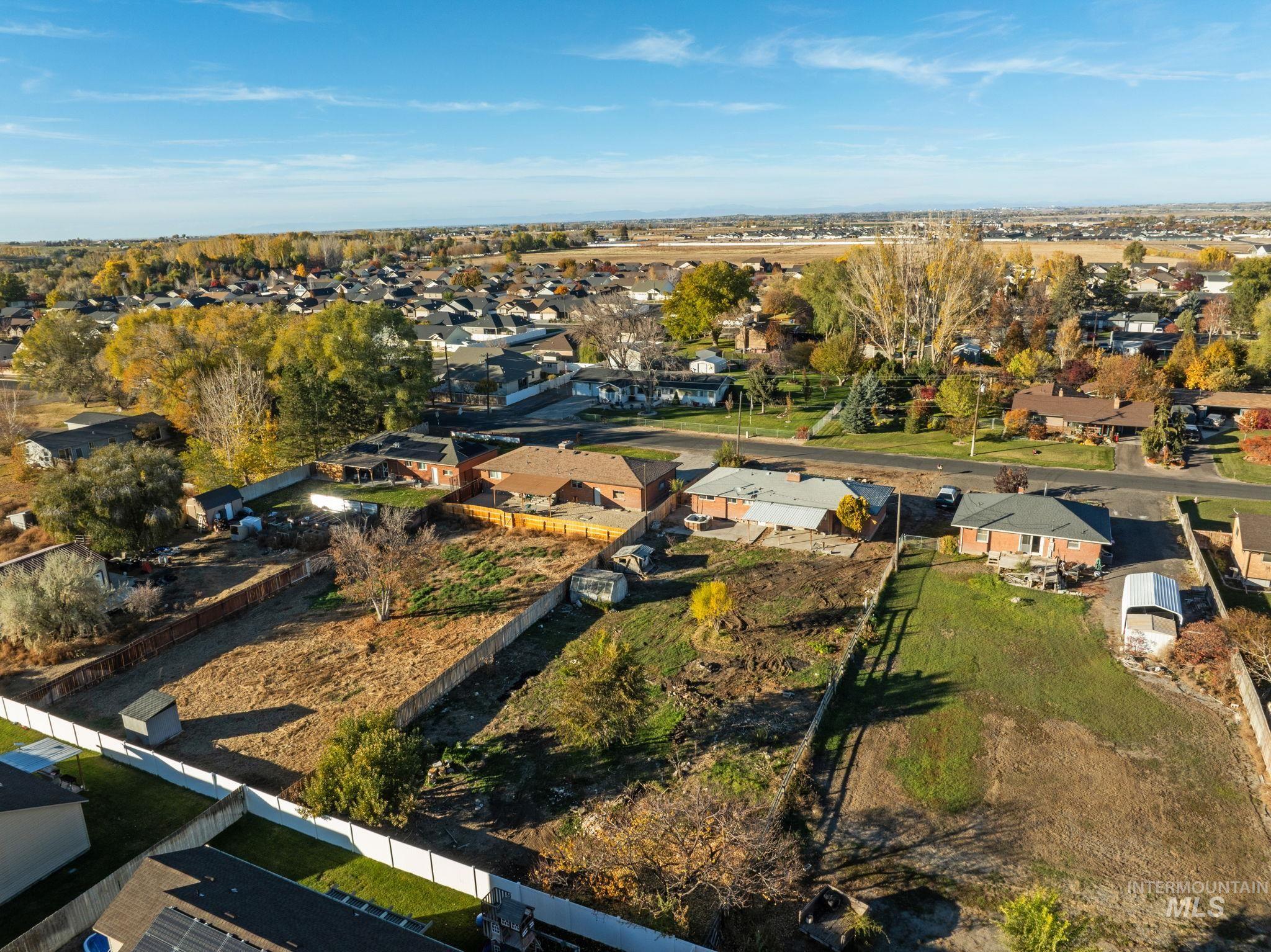 Aerial view of property and surrounding area with nearby suburban area
