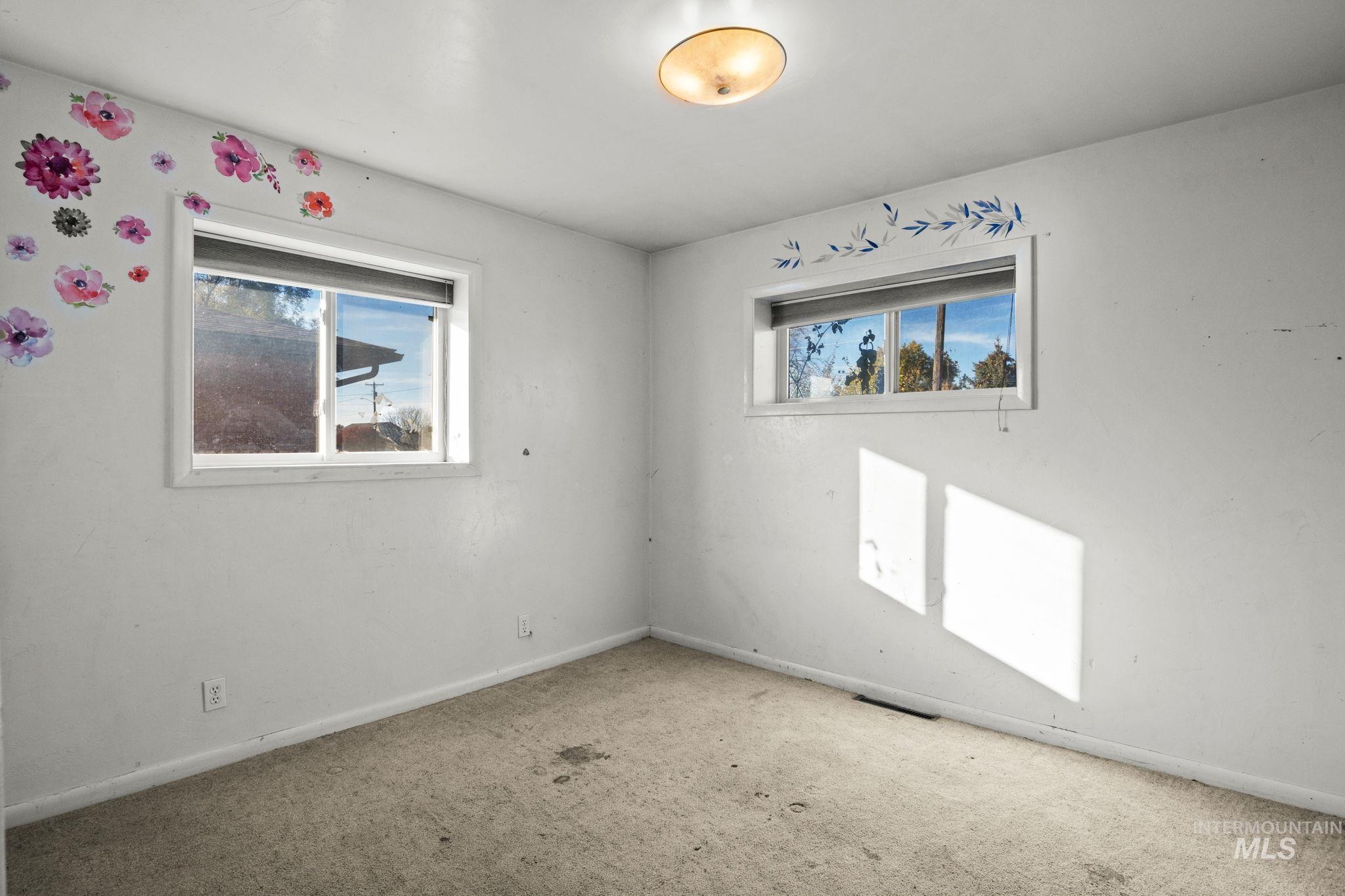Carpeted empty room featuring baseboards