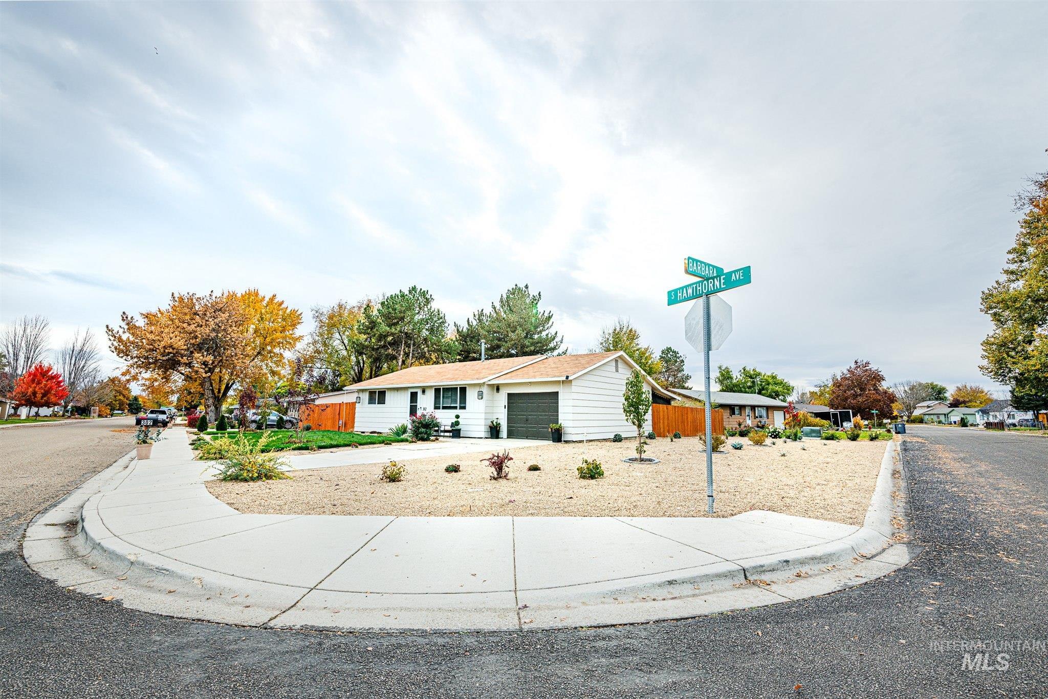 Ranch-style home featuring a garage, a residential view, and concrete driveway
