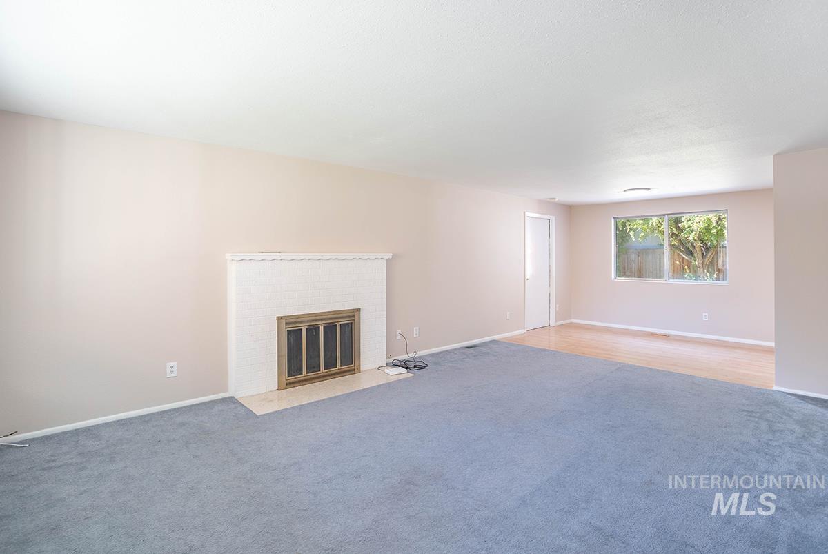 Unfurnished living room featuring a fireplace and carpet floors