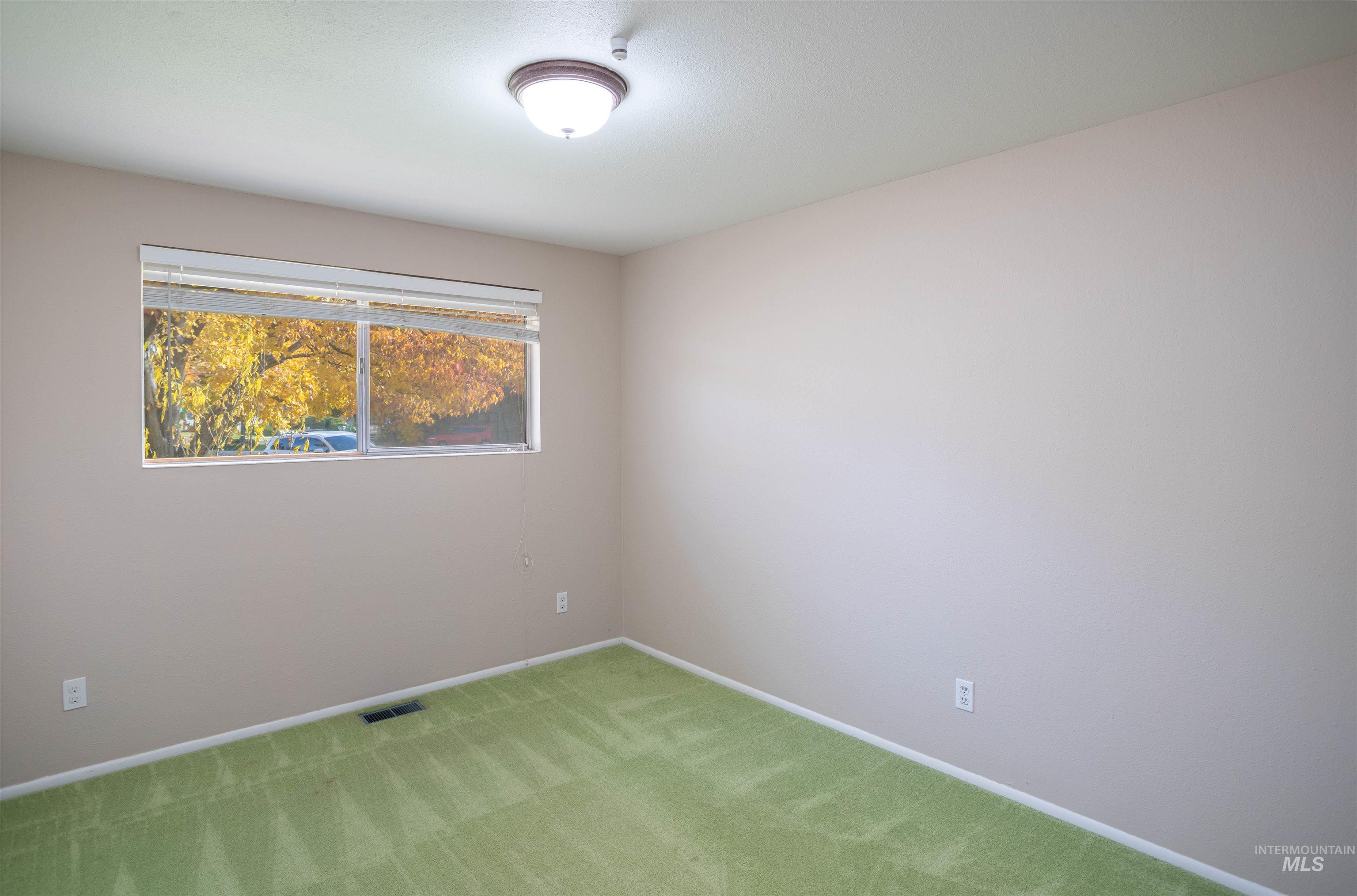 Empty room with carpet floors and baseboards