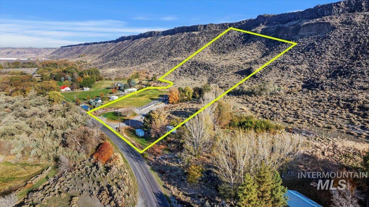 Aerial view of property's location with property parcel outlined and a mountain backdrop