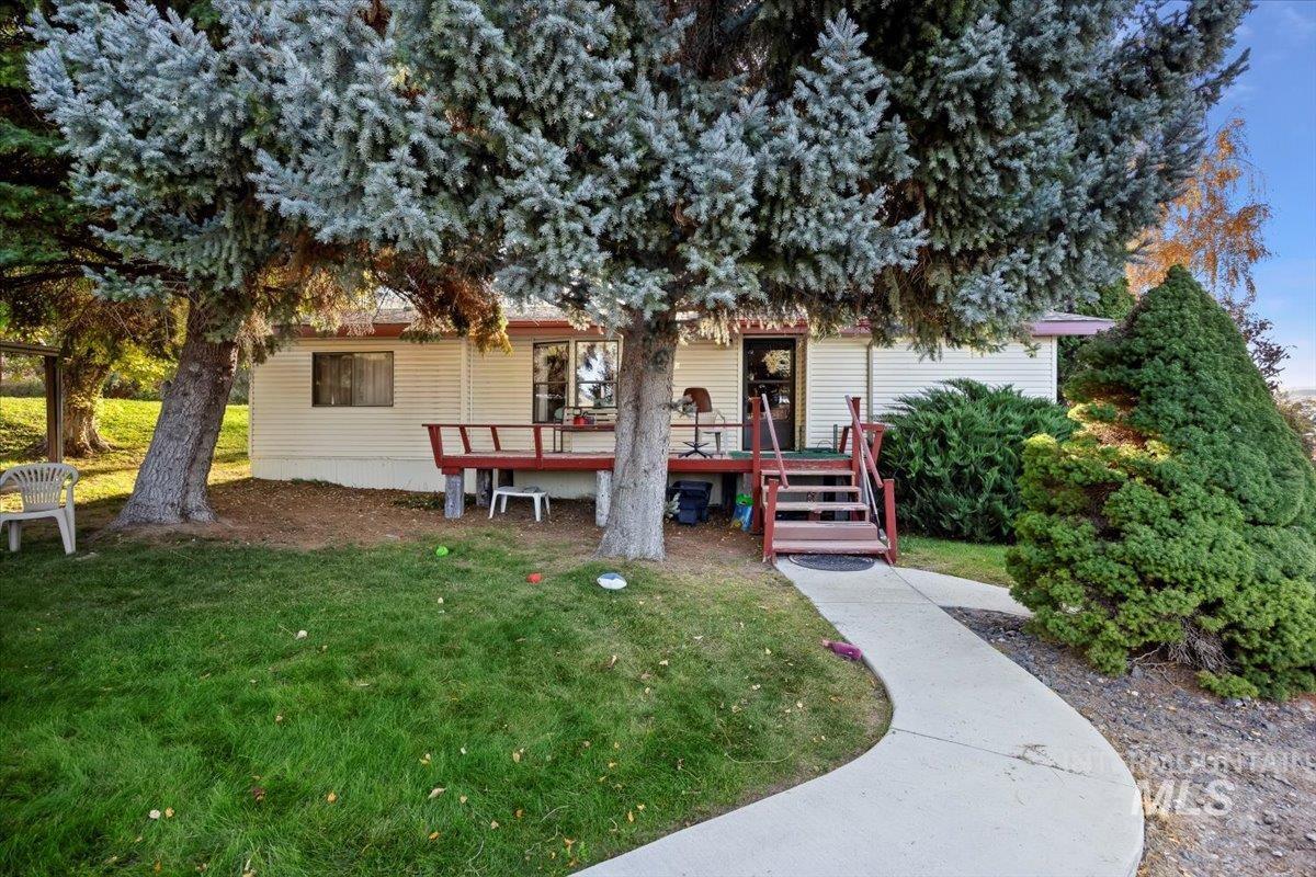 Back of property featuring a wooden deck and a lawn