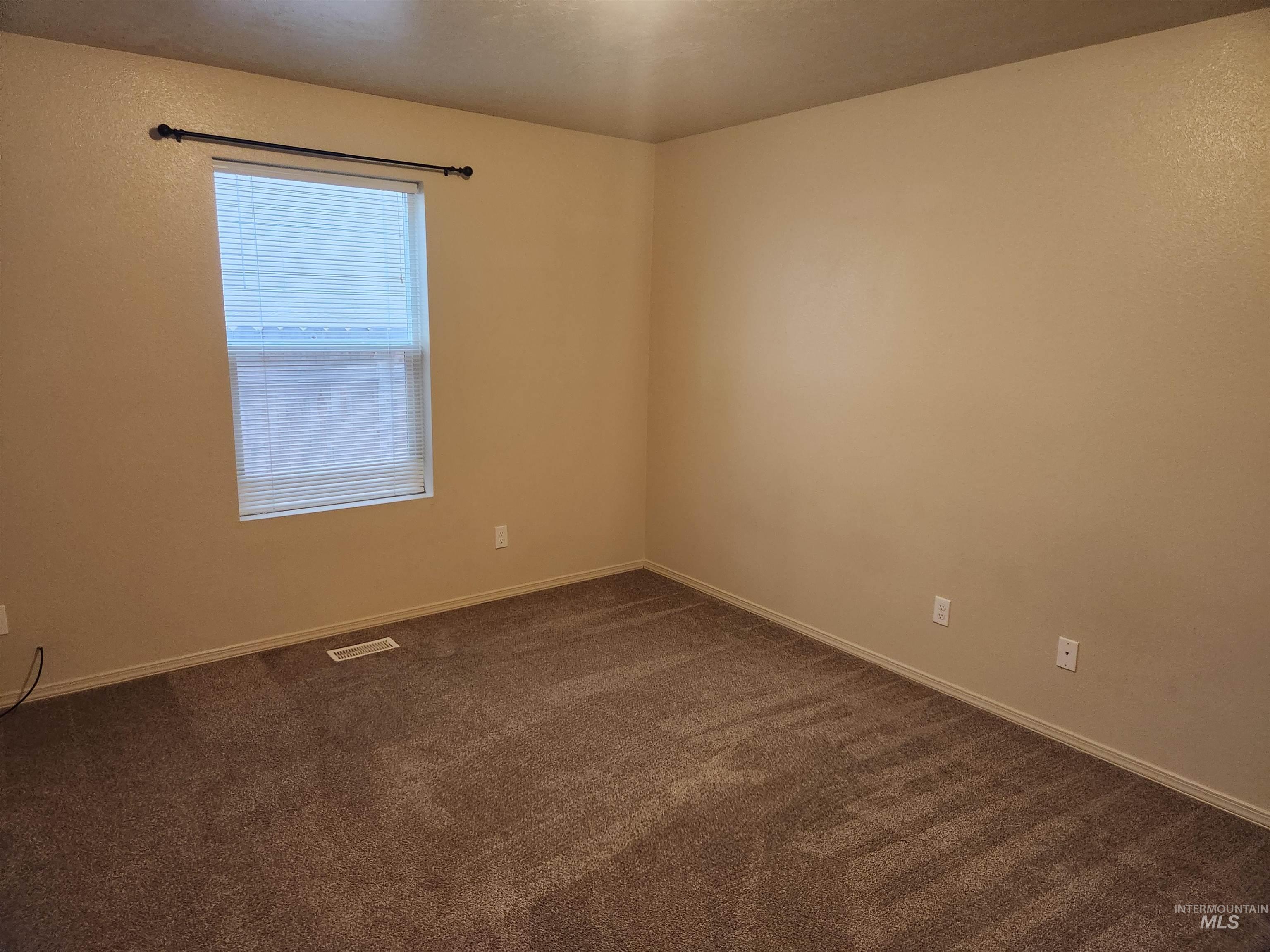 Empty room featuring dark carpet