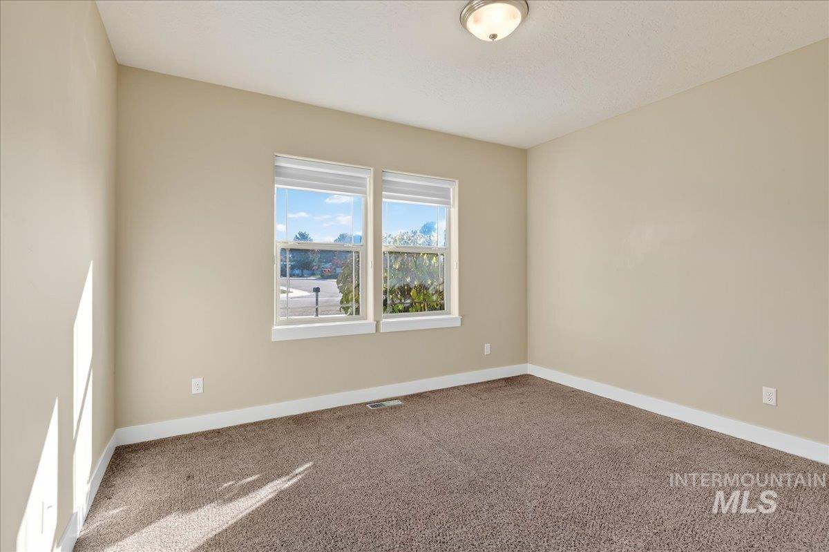 Spare room featuring carpet floors and baseboards