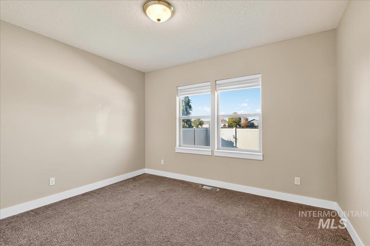 Unfurnished room featuring carpet flooring and a textured ceiling