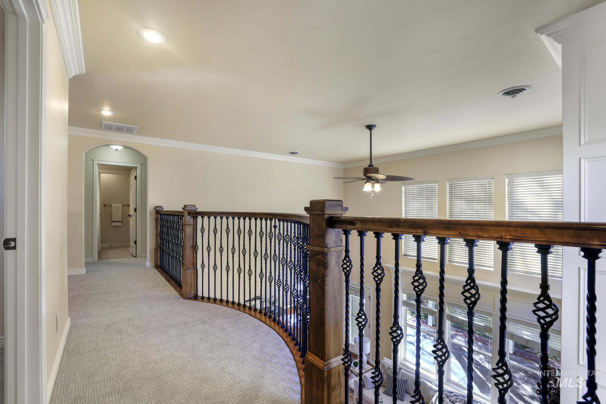 Hall featuring crown molding, carpet floors, recessed lighting, and arched walkways