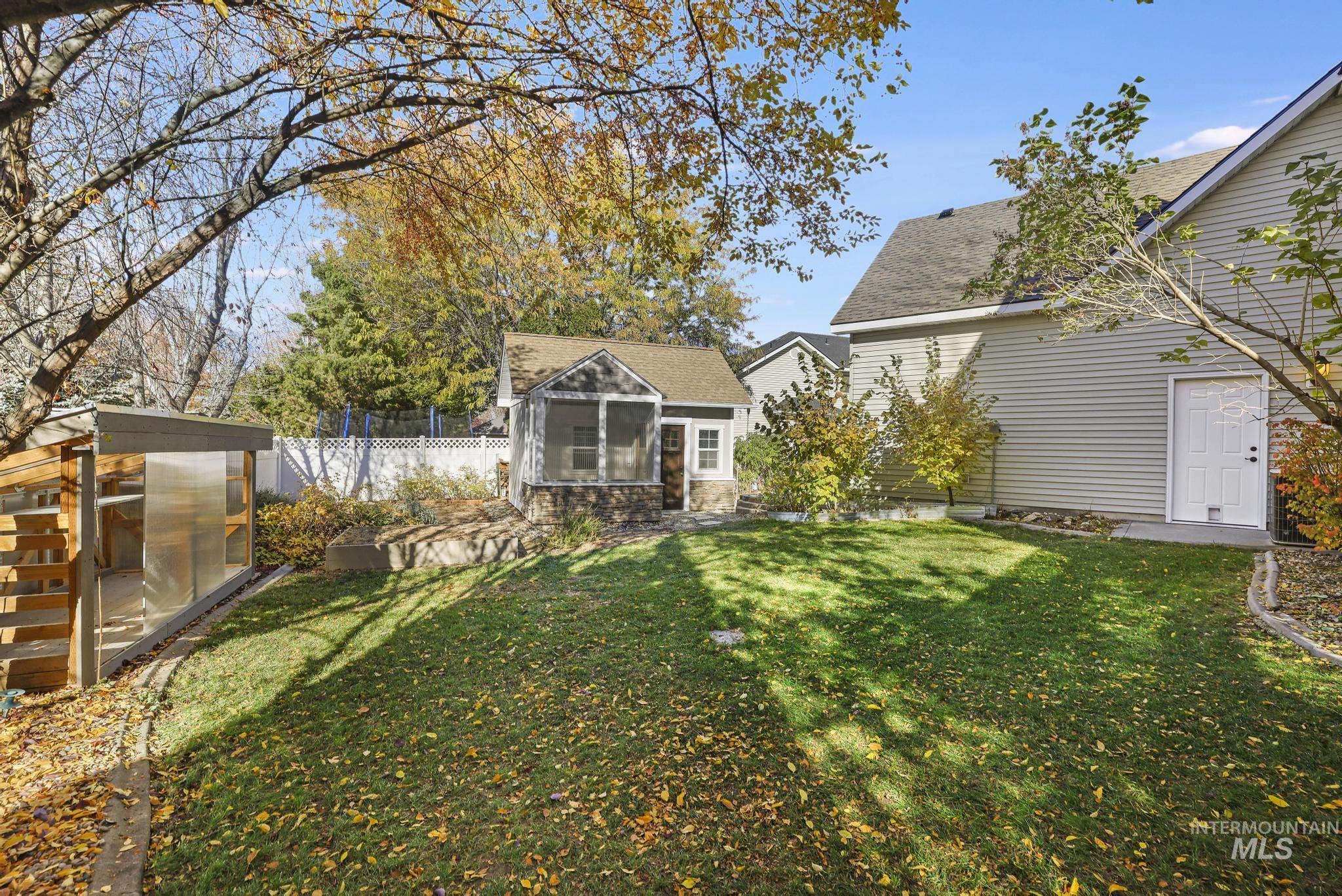 View of yard featuring an outbuilding, an exterior structure, and a sunroom