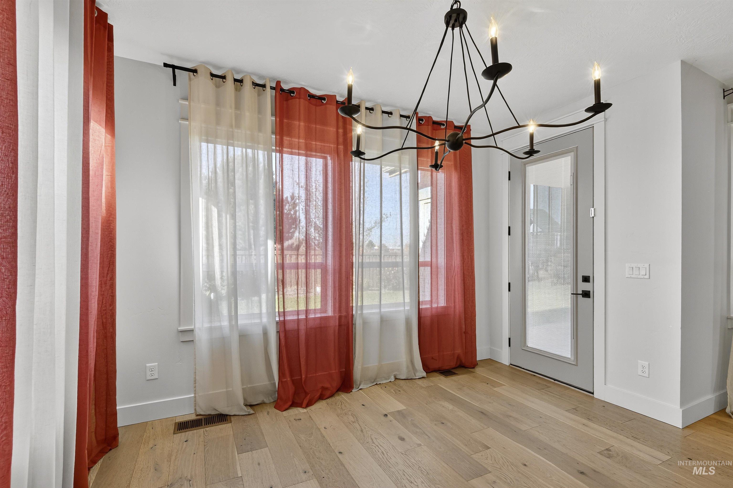 Unfurnished dining area featuring light wood-style floors and a chandelier