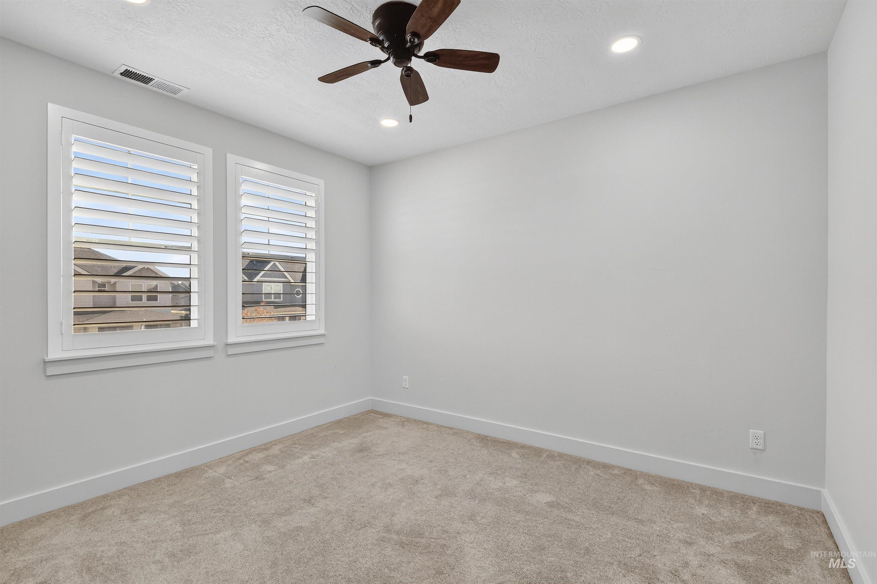Spare room with carpet, a textured ceiling, ceiling fan, and recessed lighting
