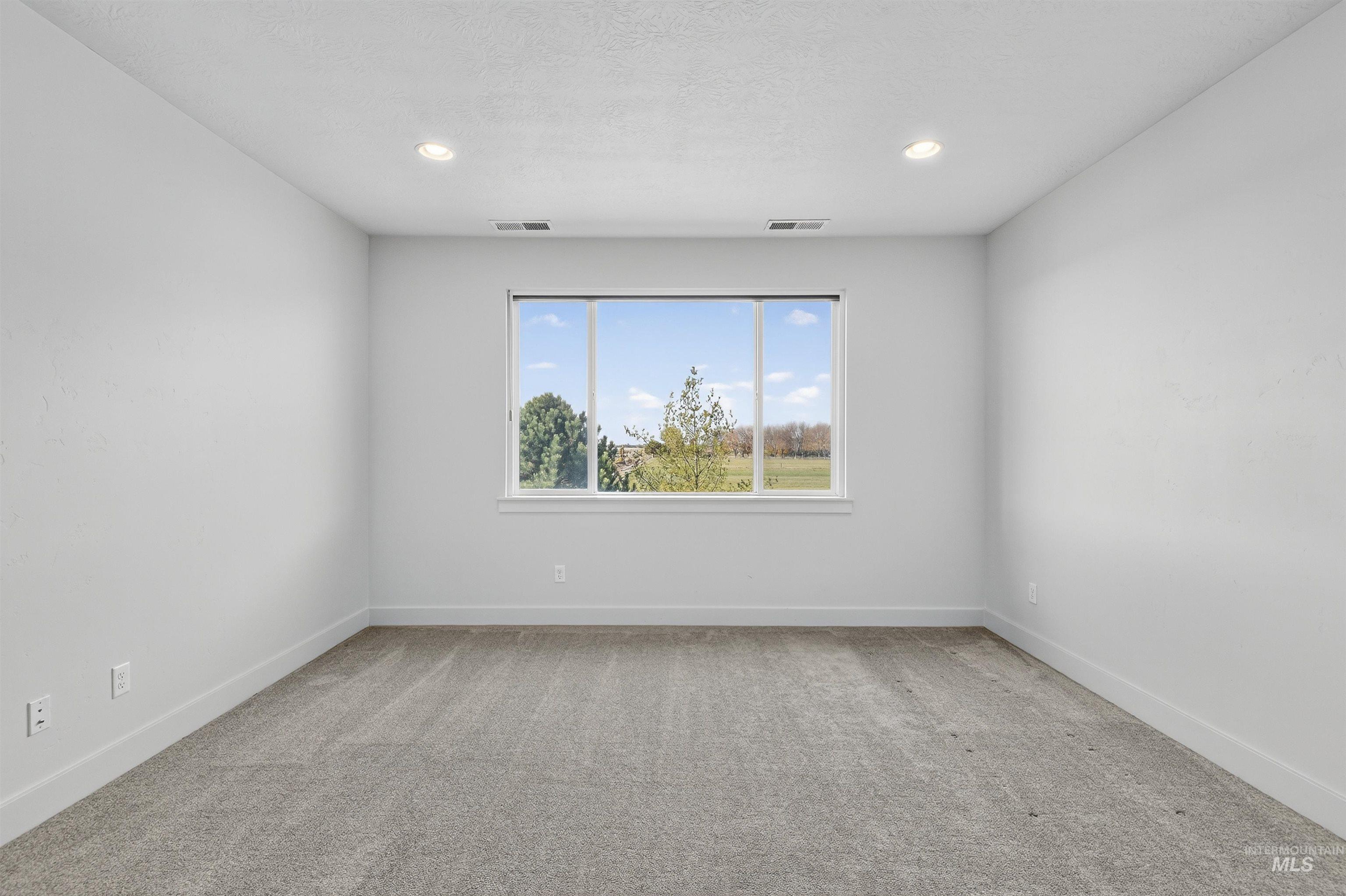 Unfurnished room featuring light carpet, recessed lighting, and a textured ceiling