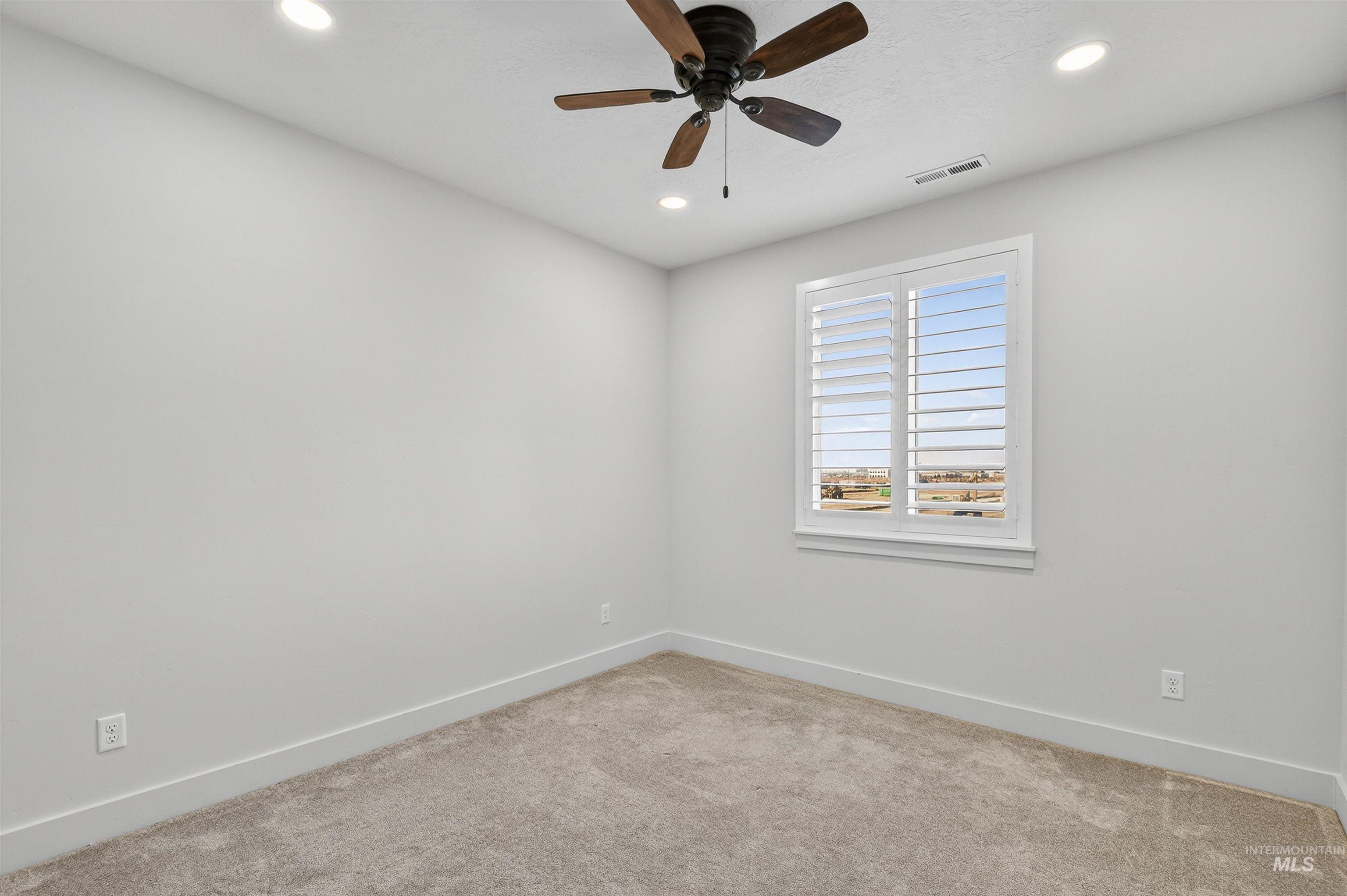 Carpeted empty room with recessed lighting and a ceiling fan
