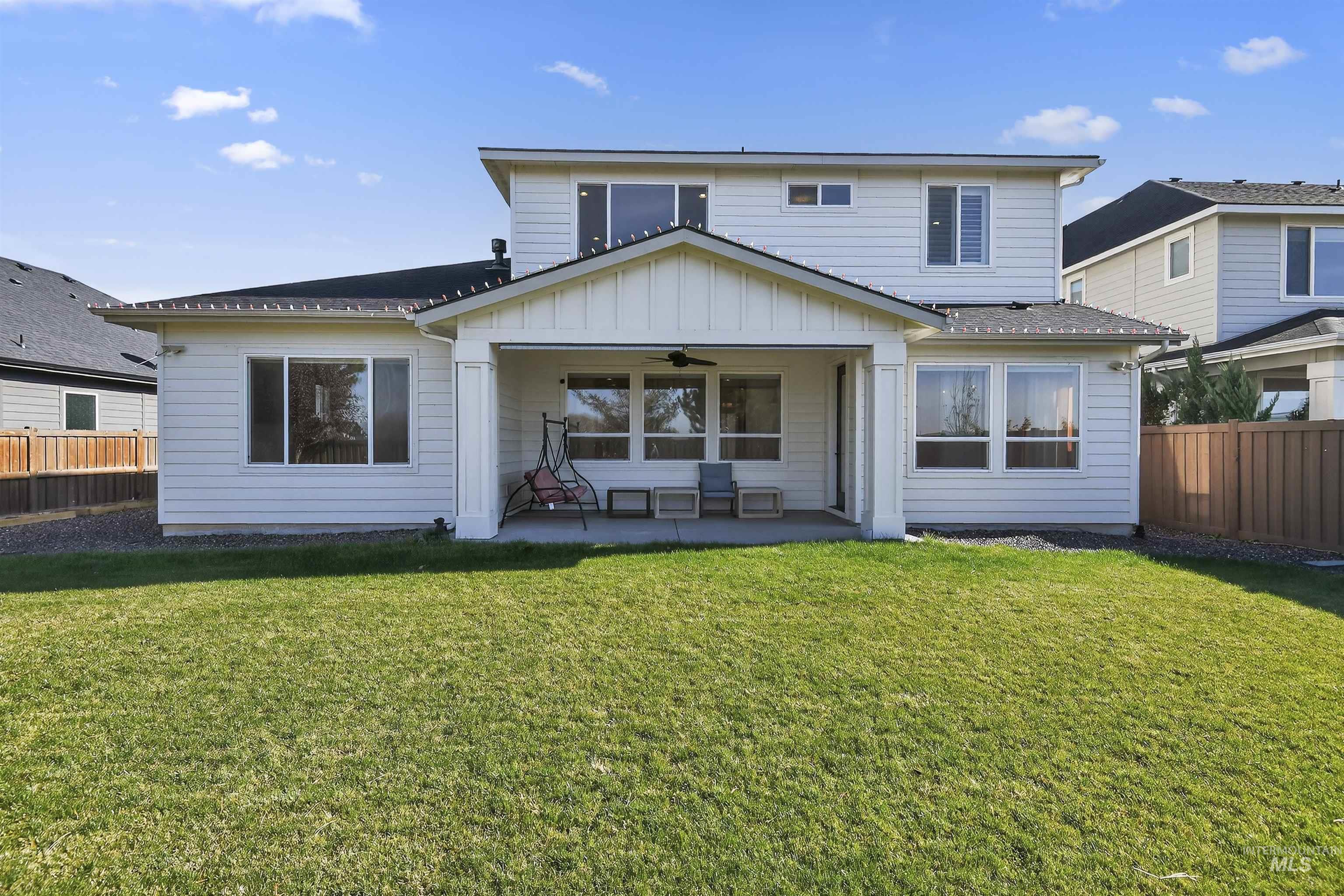 Rear view of house with a ceiling fan, a fenced backyard, a patio, and board and batten siding