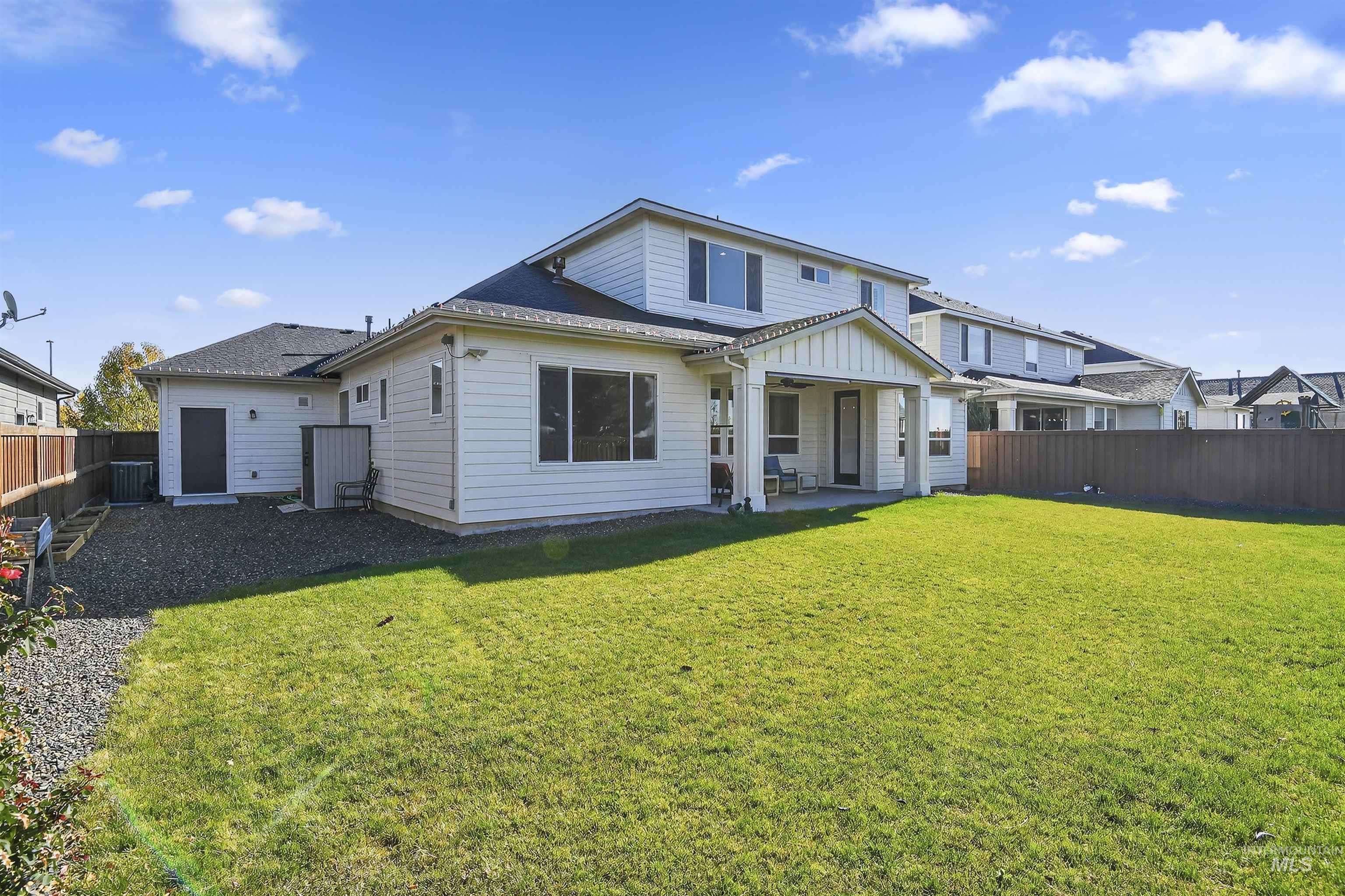 Back of property featuring a patio, a fenced backyard, and a shingled roof