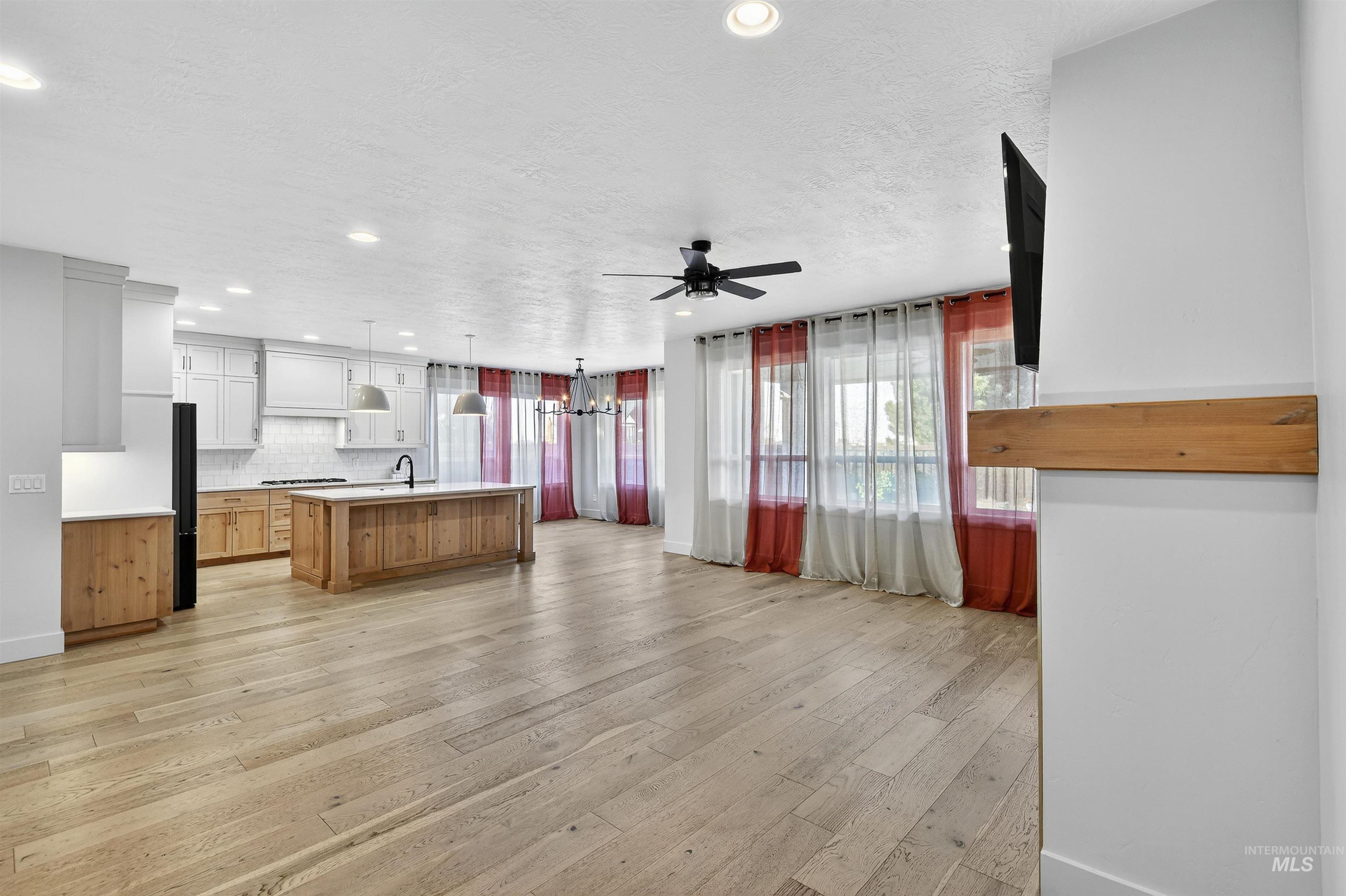 Kitchen featuring light countertops, a chandelier, light wood-style floors, decorative backsplash, and open floor plan