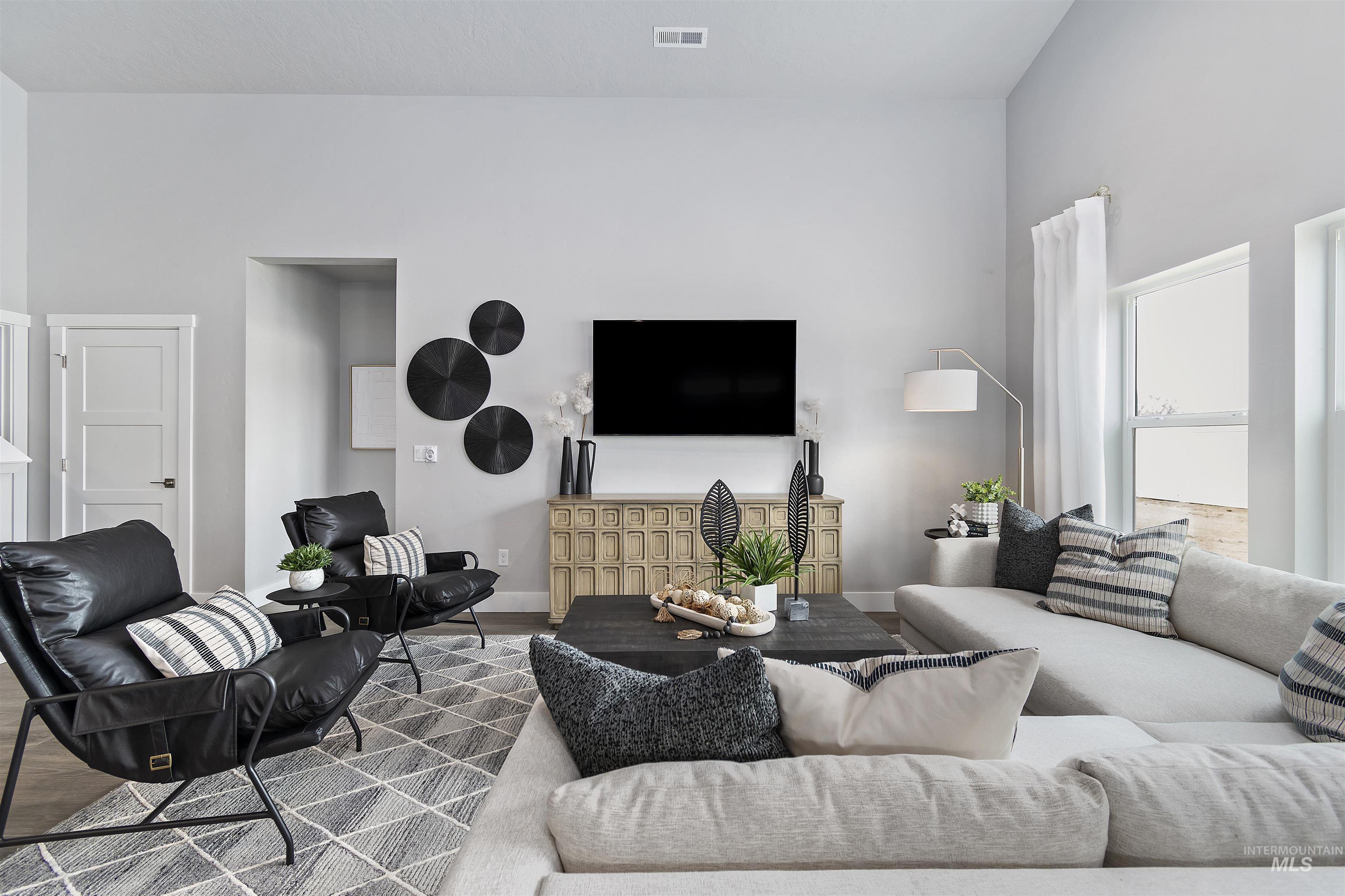 Living room featuring wood finished floors and a towering ceiling
