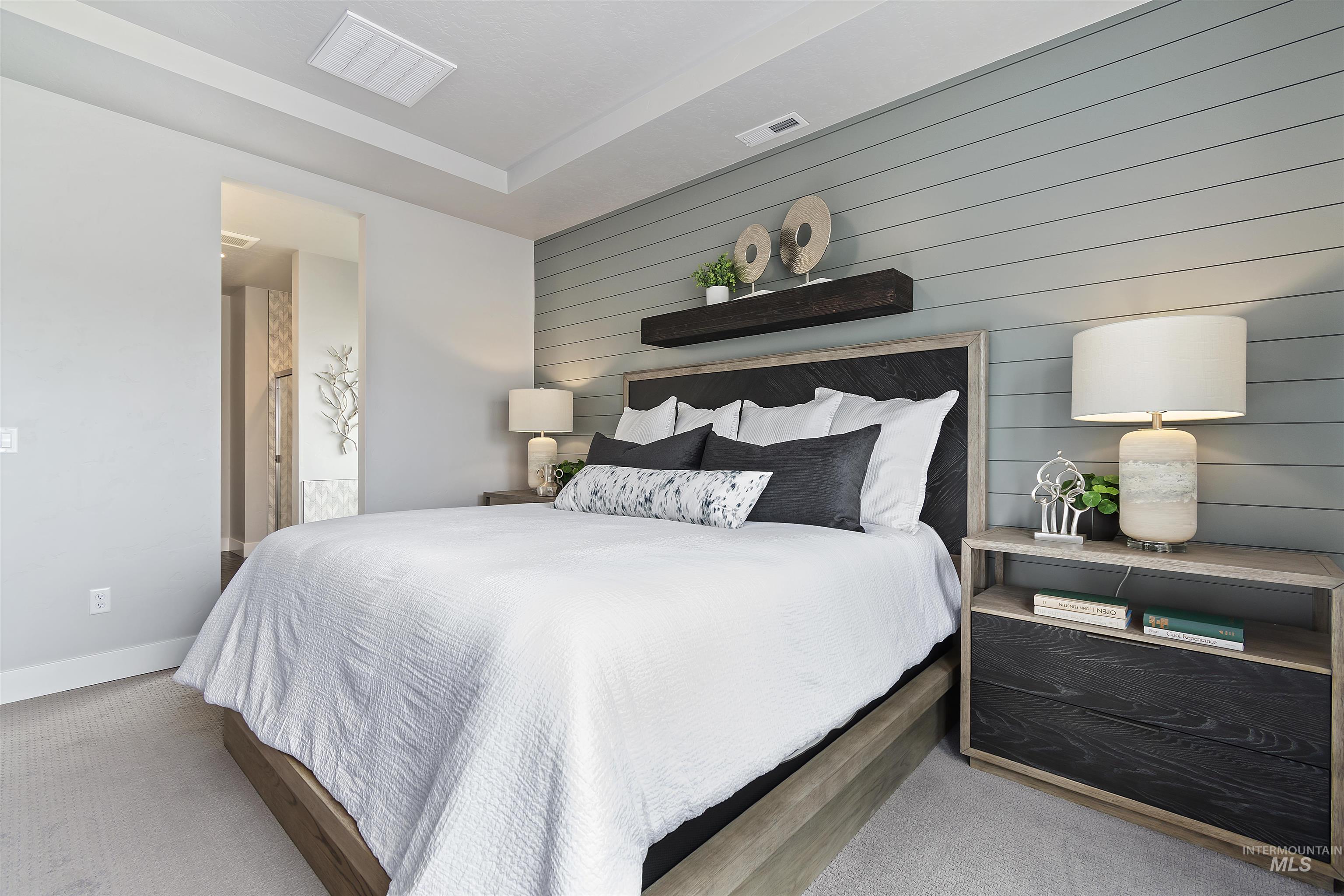 Carpeted bedroom featuring wooden walls and ensuite bath