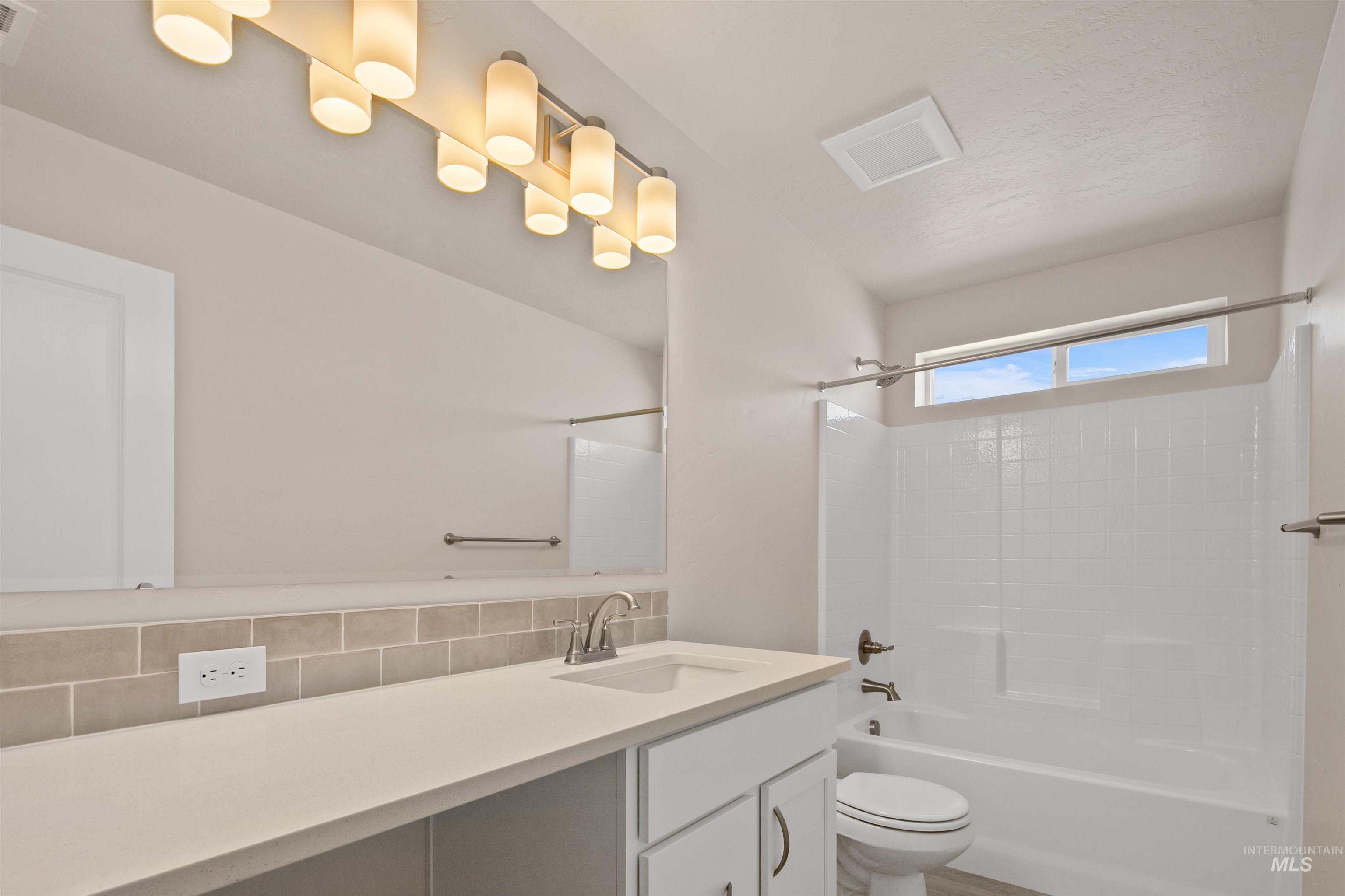 Bathroom with  shower combination, decorative backsplash, and vanity