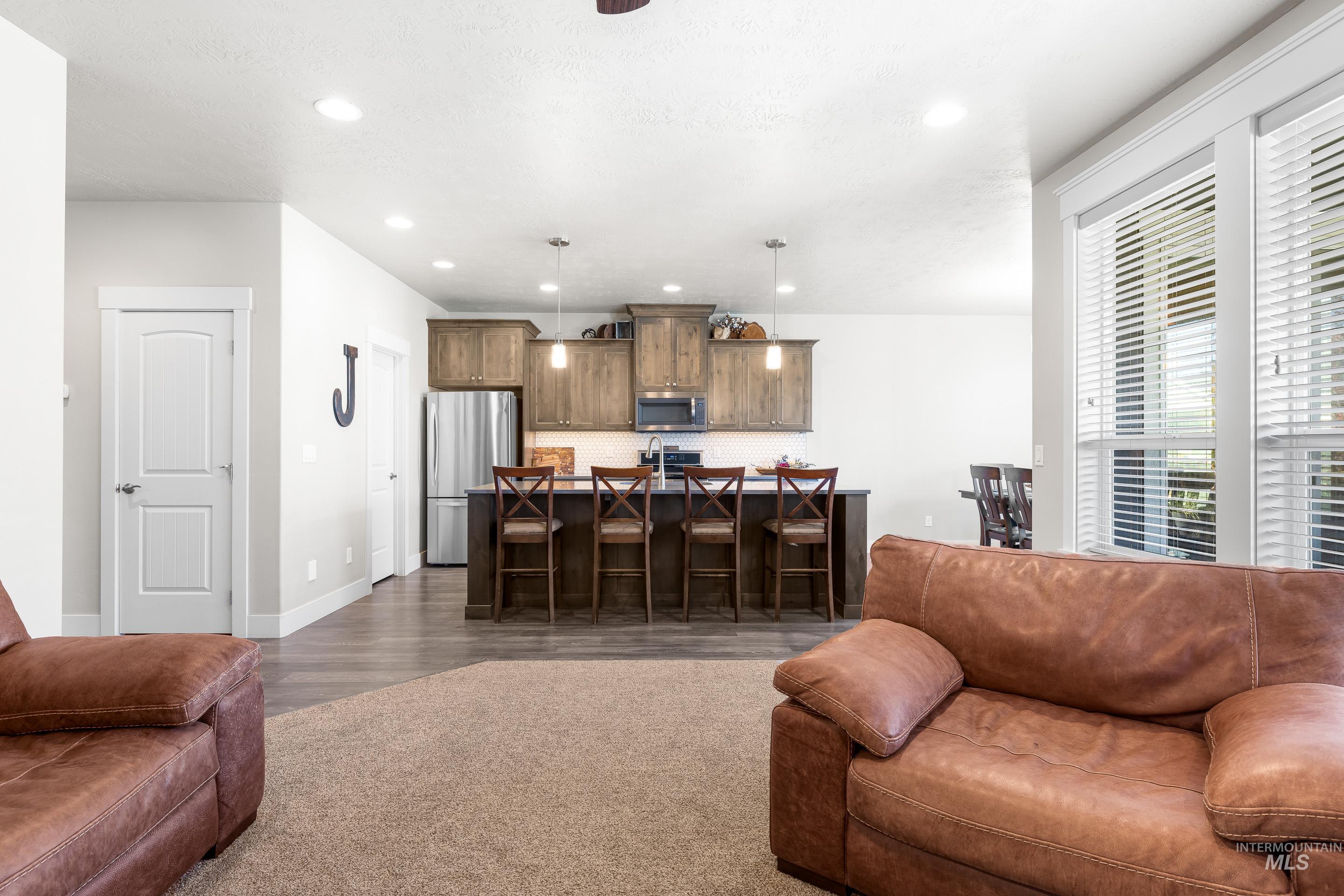 Living room with recessed lighting and dark wood-style floors