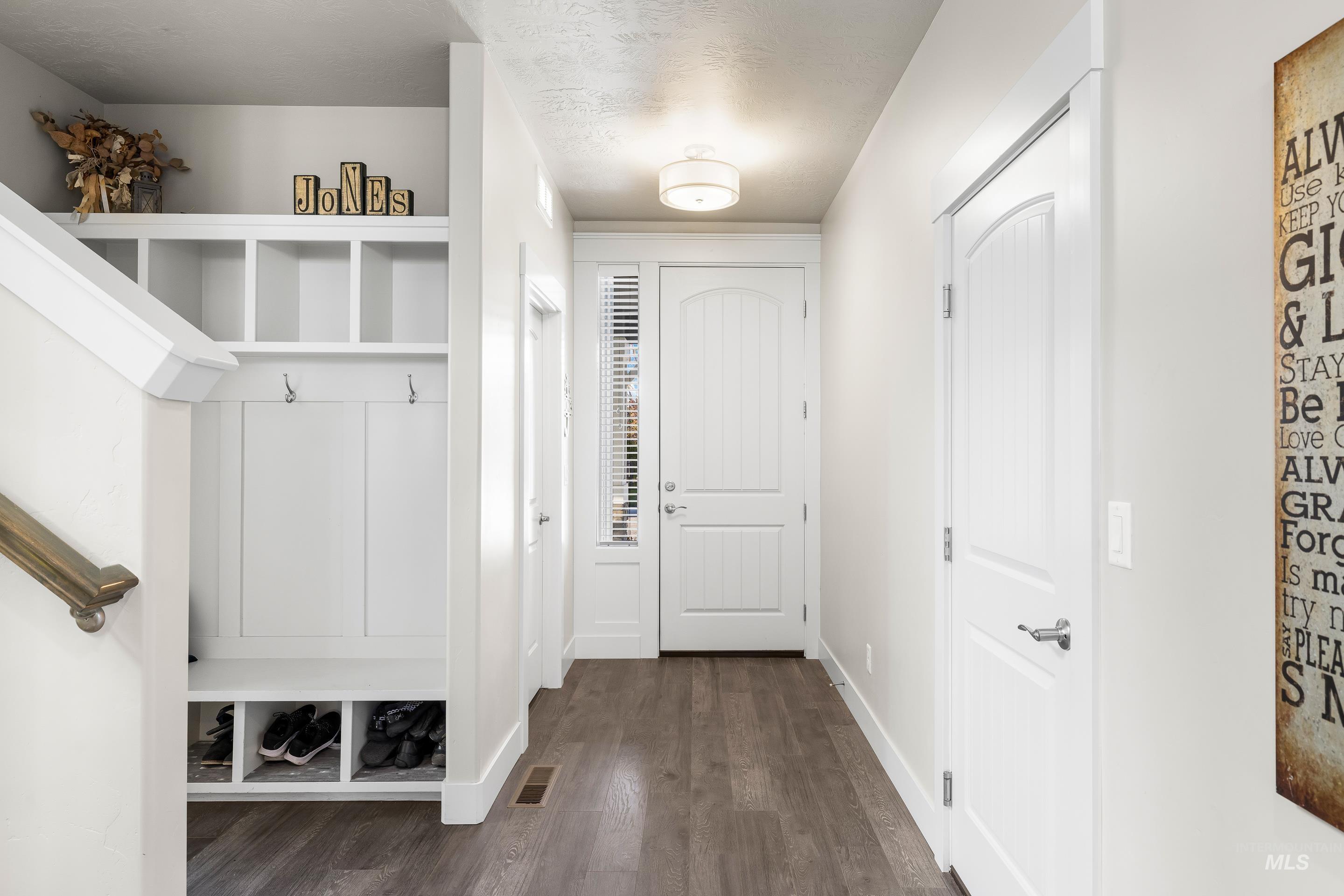 Mudroom featuring dark wood-style flooring and a textured ceiling