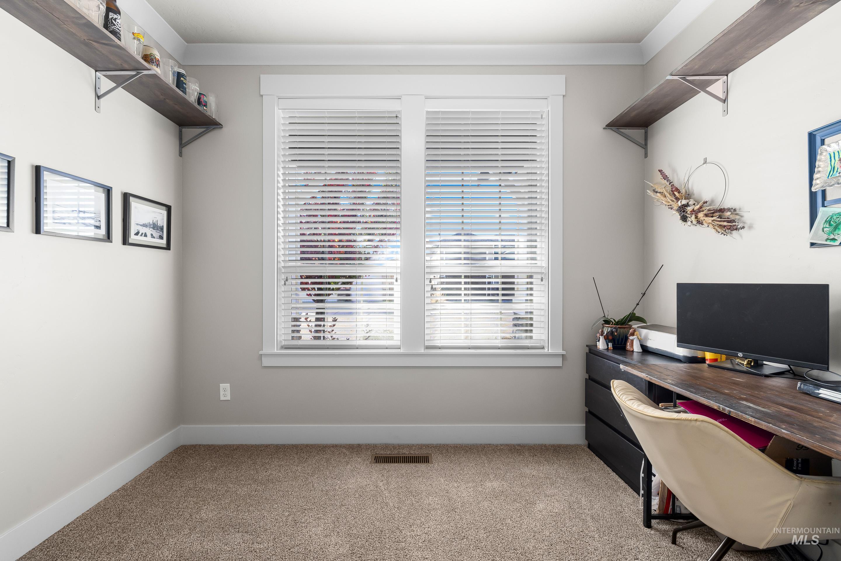 Home office featuring light colored carpet and crown molding