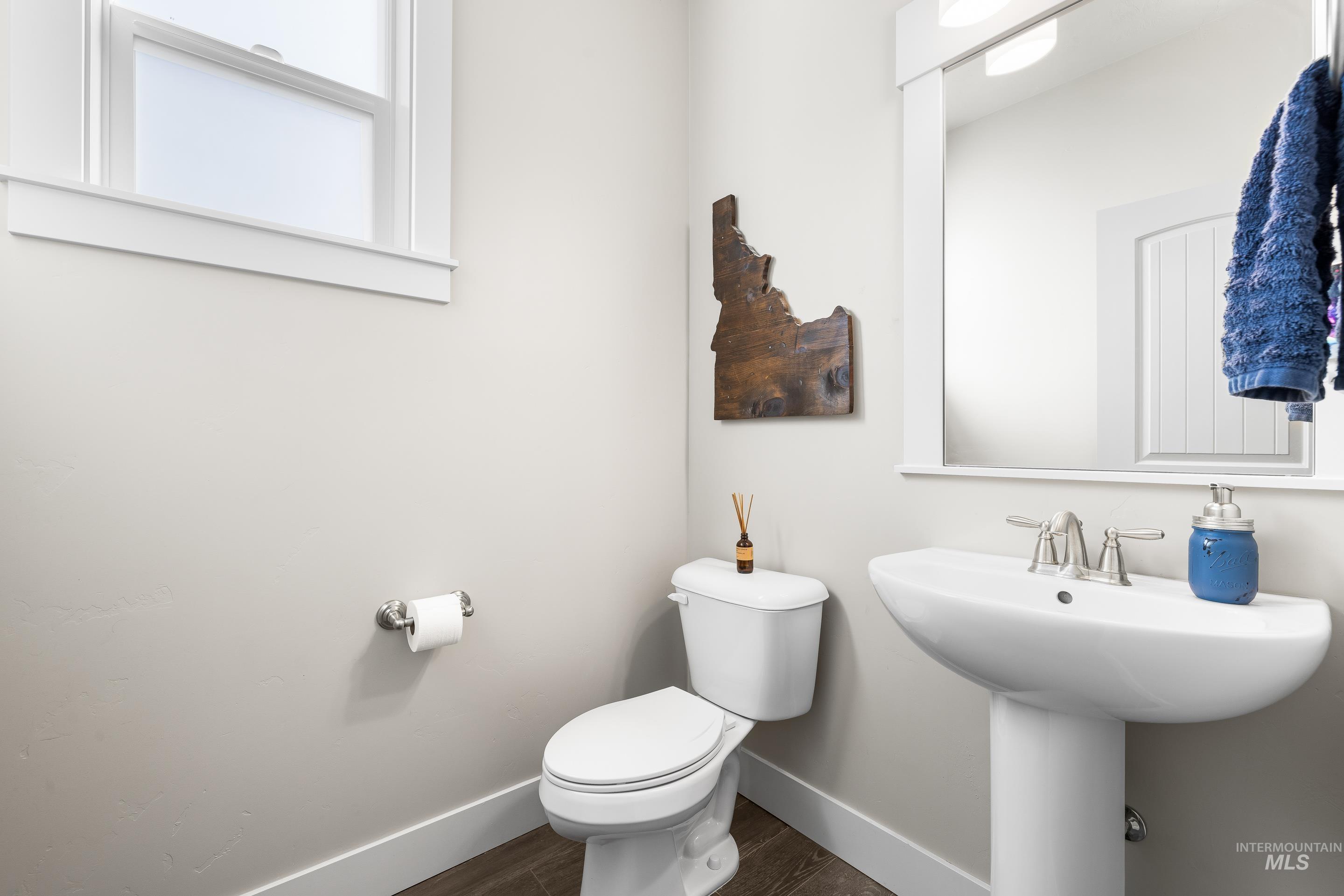 Bathroom with baseboards and dark wood-type flooring