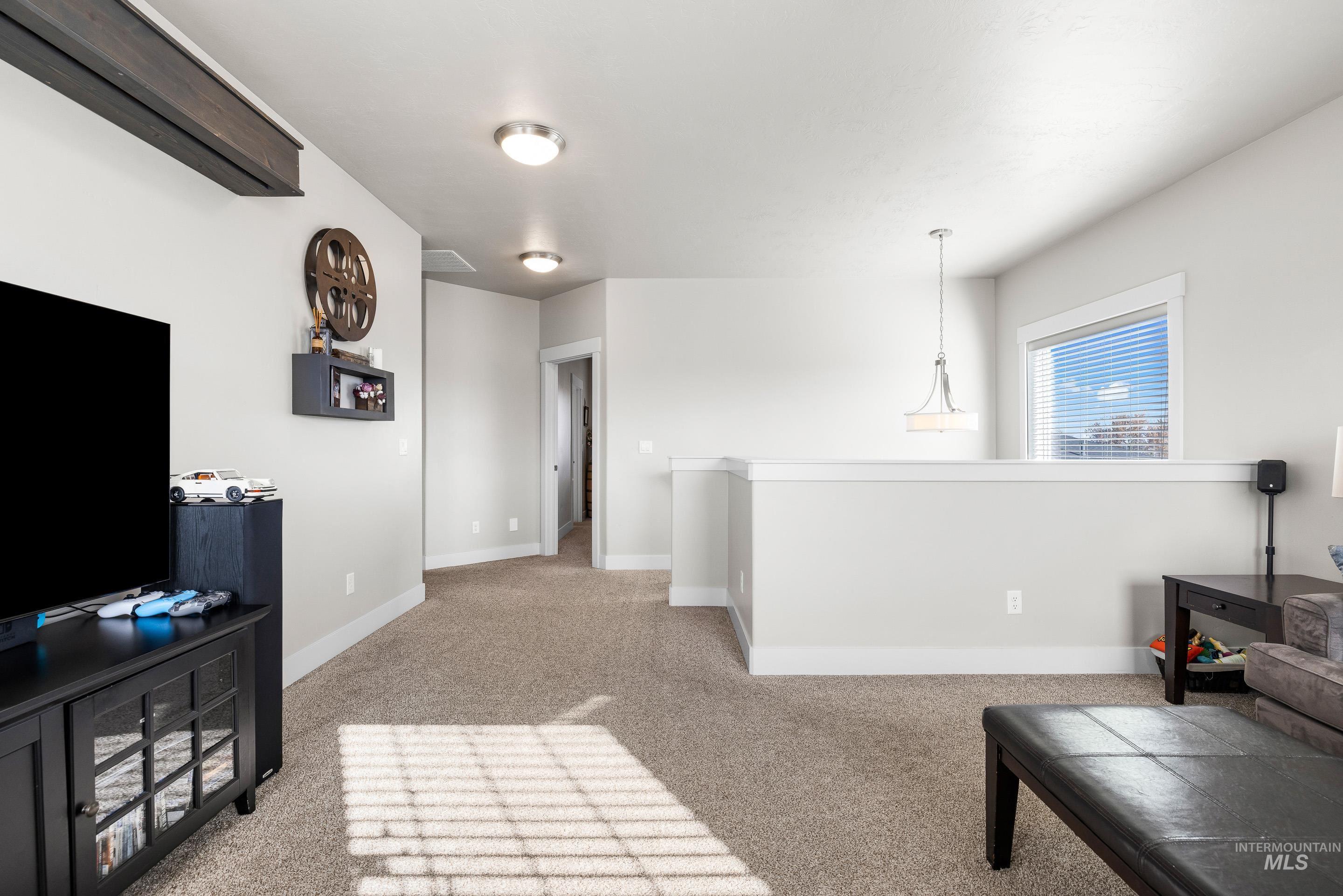 Living area featuring light colored carpet and baseboards