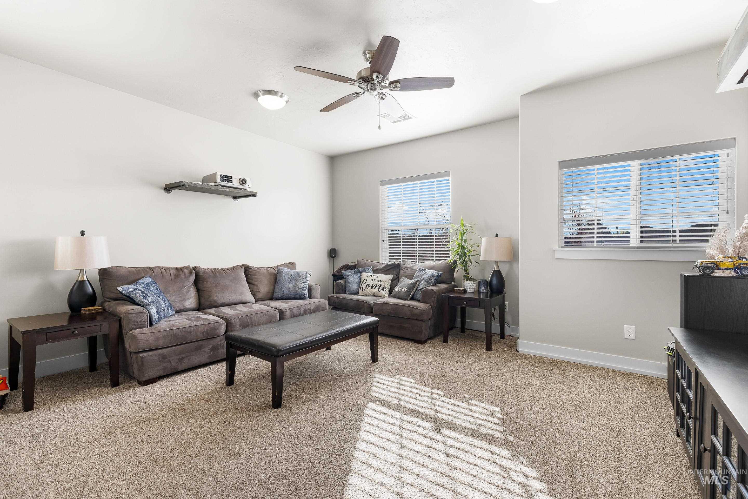 Living room featuring light carpet and ceiling fan