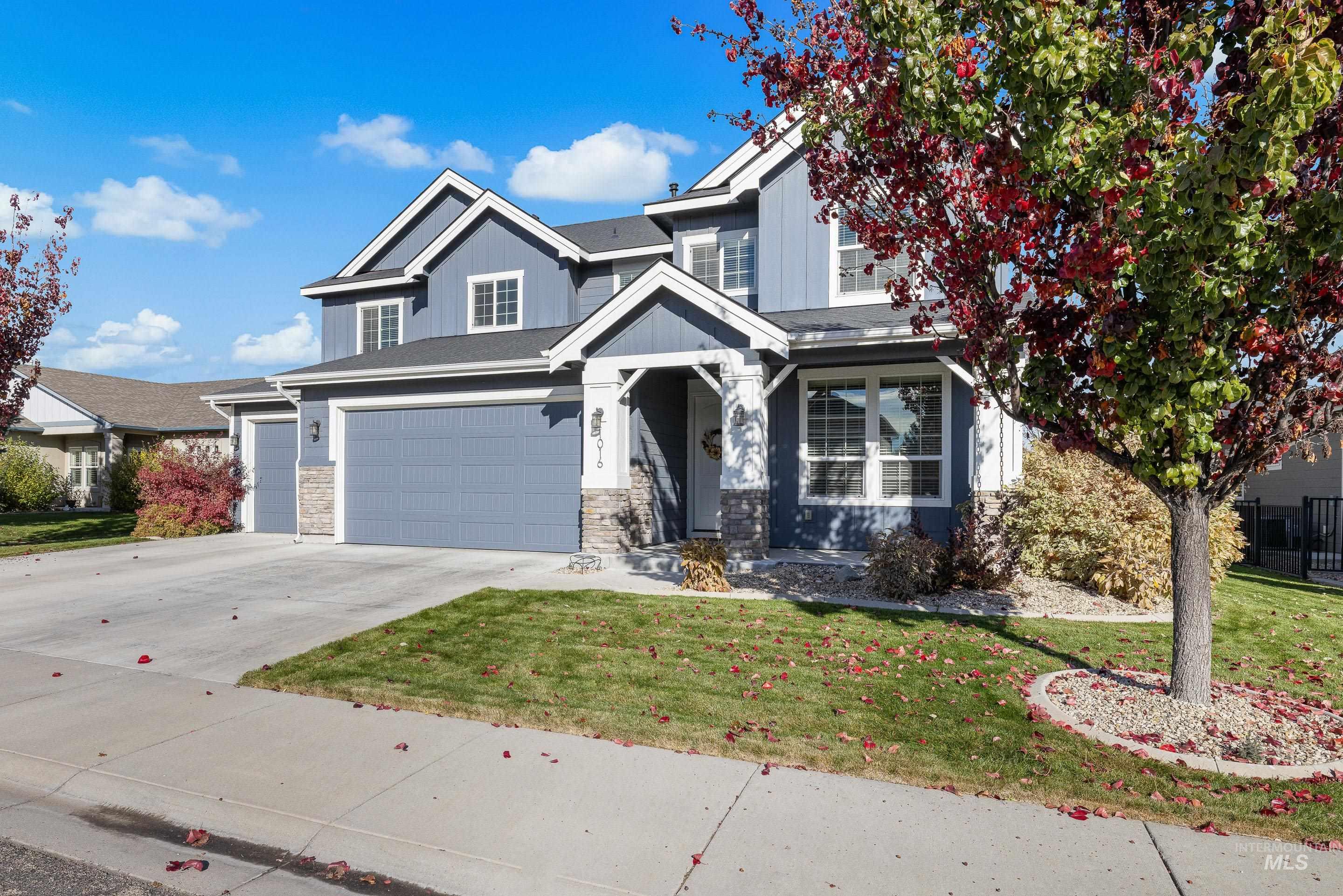 View of front of property with a front lawn, concrete driveway, an attached garage, and board and batten siding