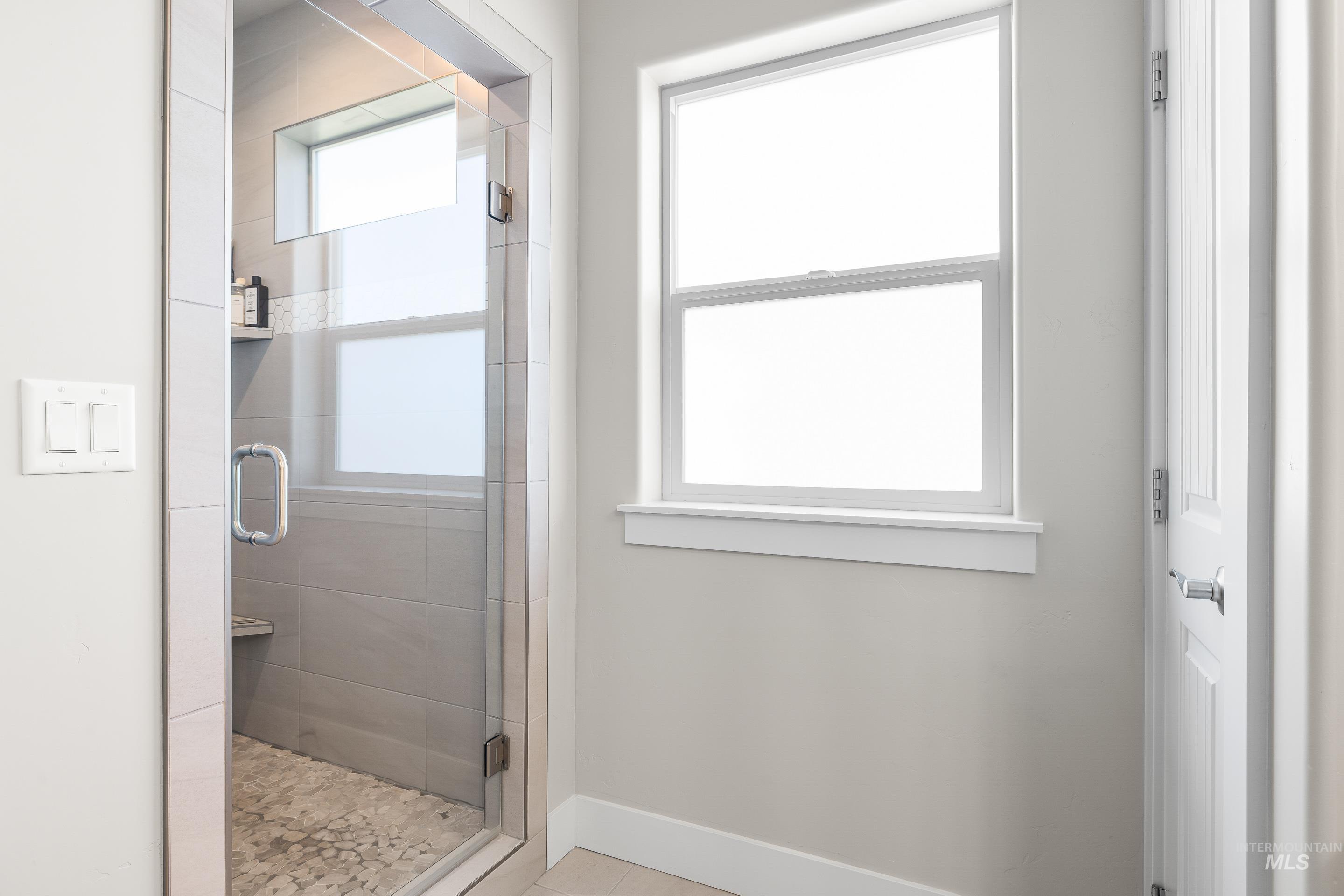 Full bathroom with a stall shower and light tile patterned flooring