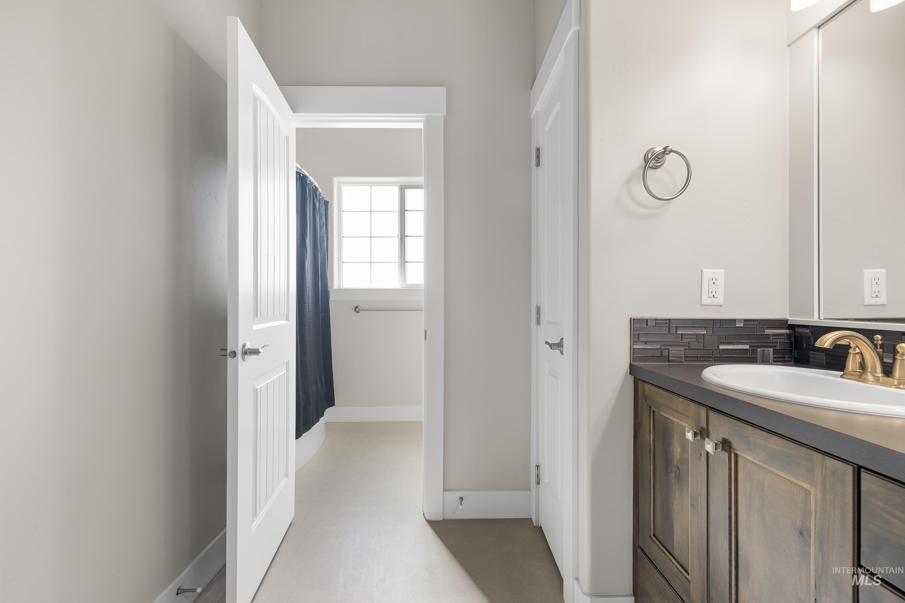 Full bathroom with vanity, a shower with curtain, and backsplash