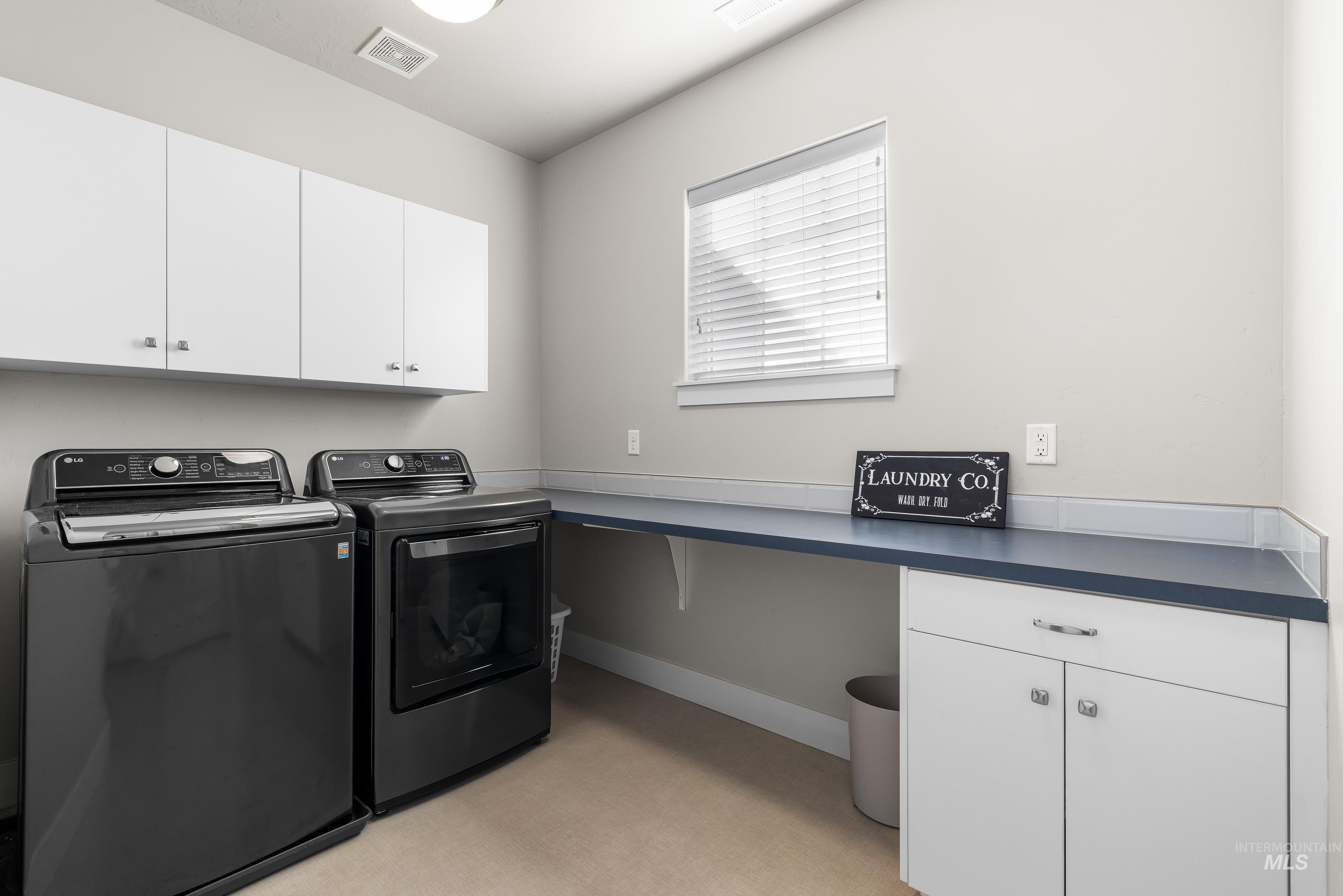 Washroom with cabinet space and washer and dryer