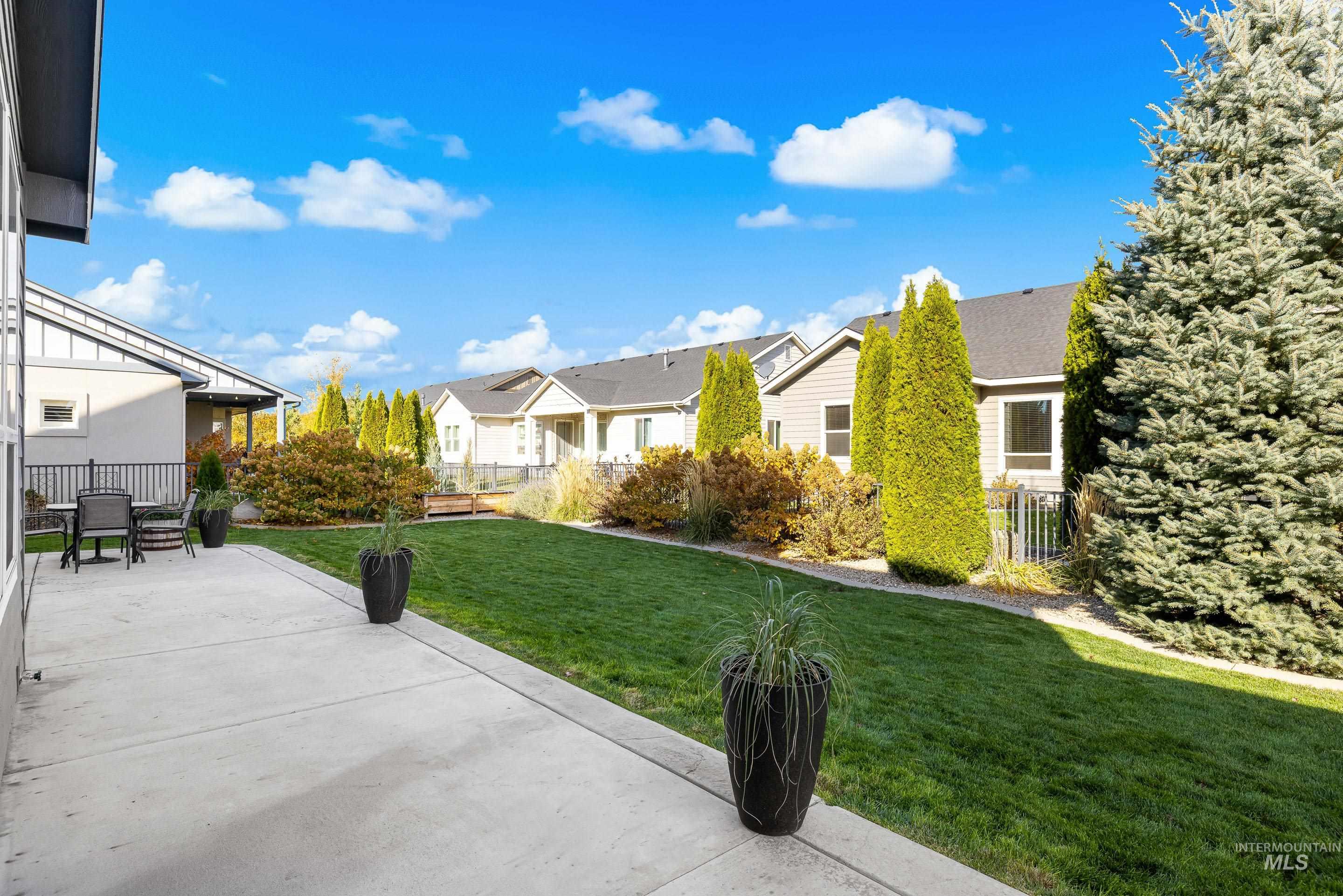 View of green lawn featuring a patio area and a residential view