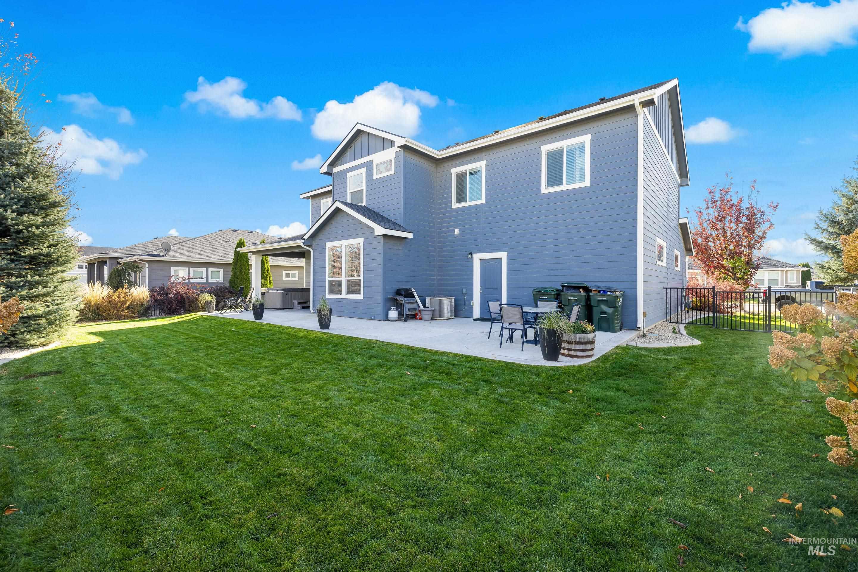 Back of house featuring a patio area, a yard, and board and batten siding