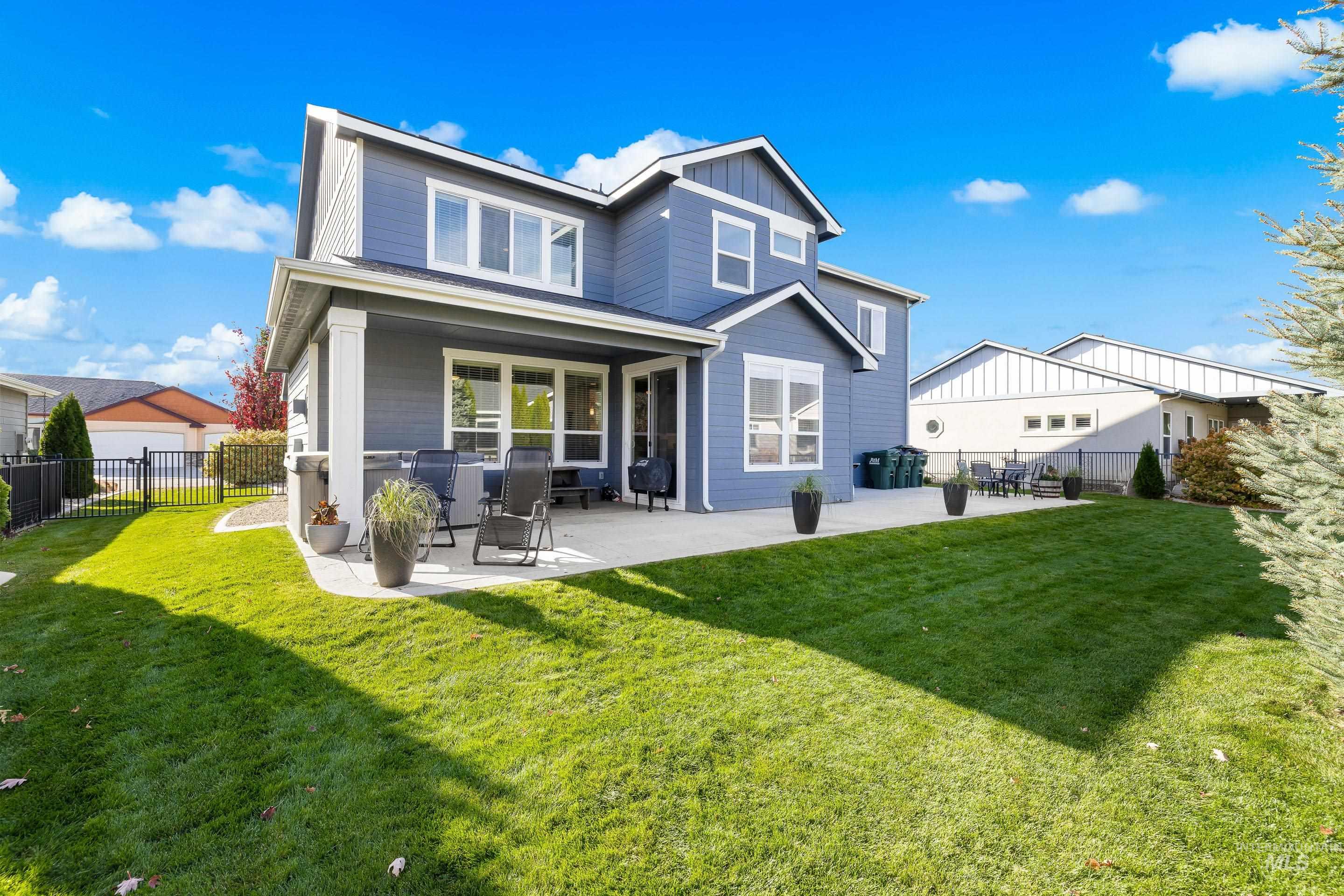 Rear view of house featuring a patio area, a fenced backyard, and board and batten siding