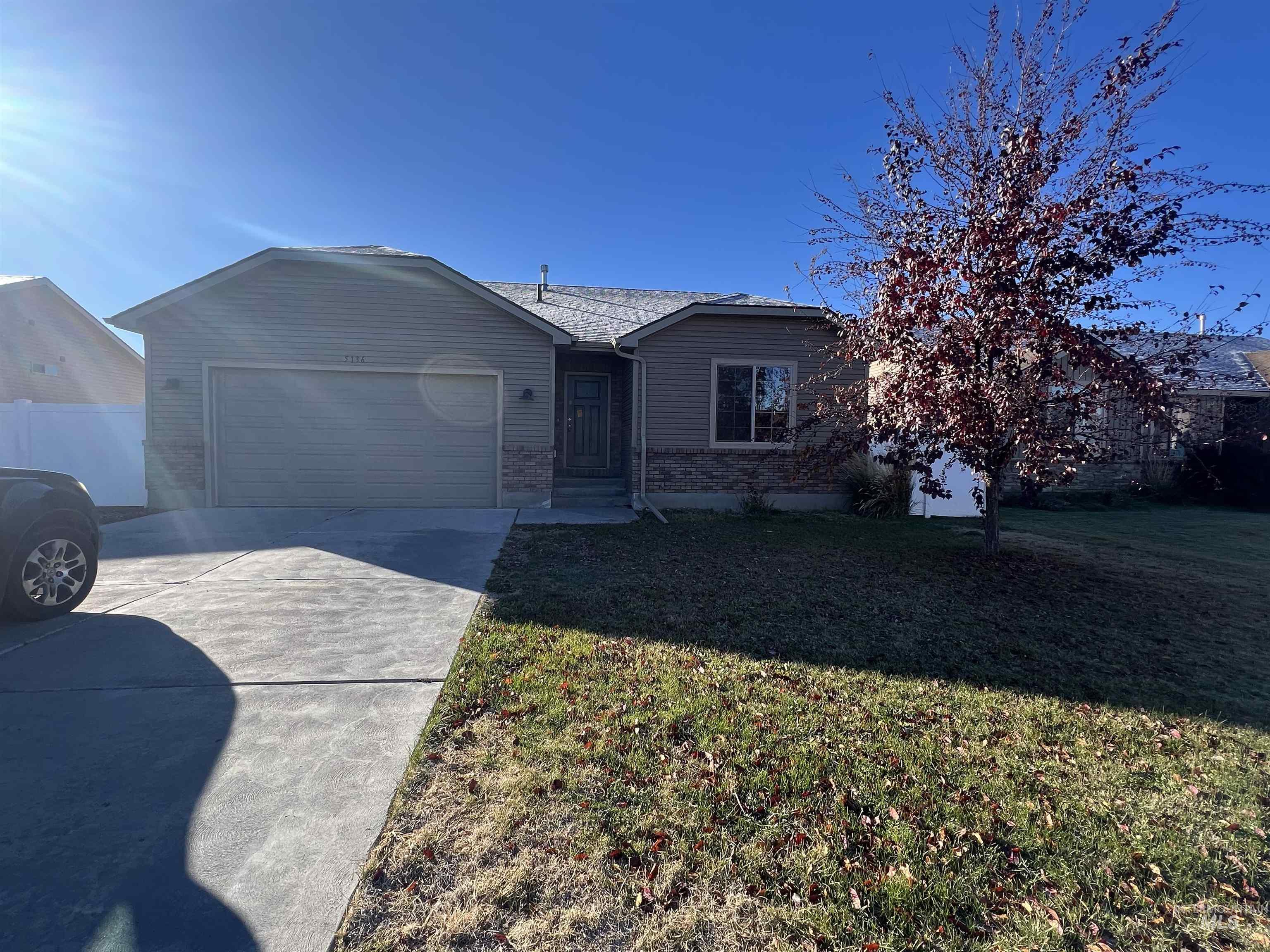 Single story home with concrete driveway, a front lawn, brick siding, and a garage