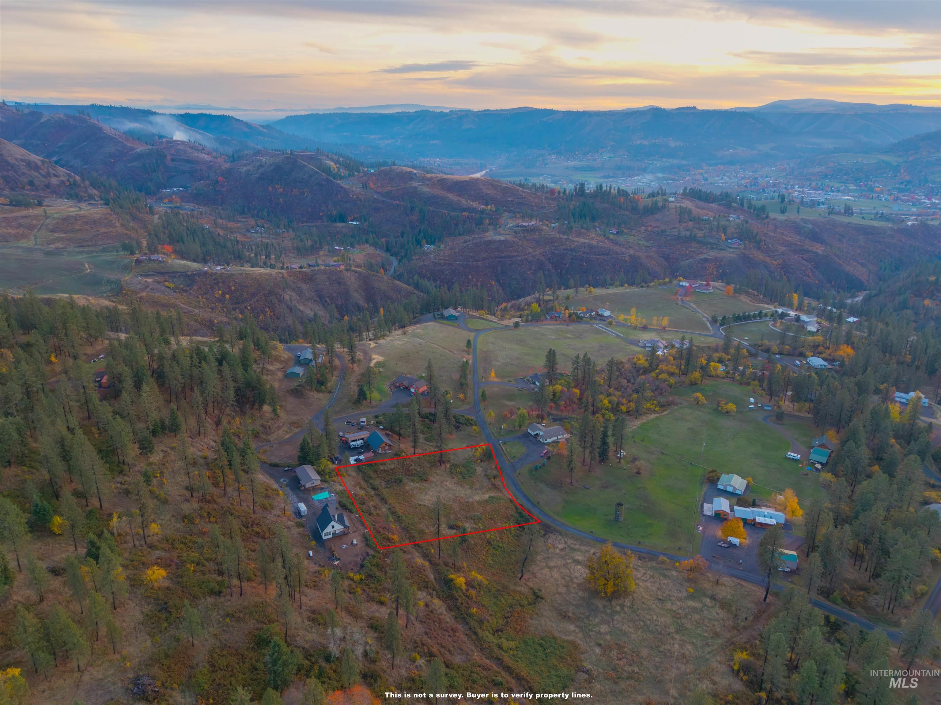 Aerial view of property and surrounding area featuring property parcel outlined and mountains