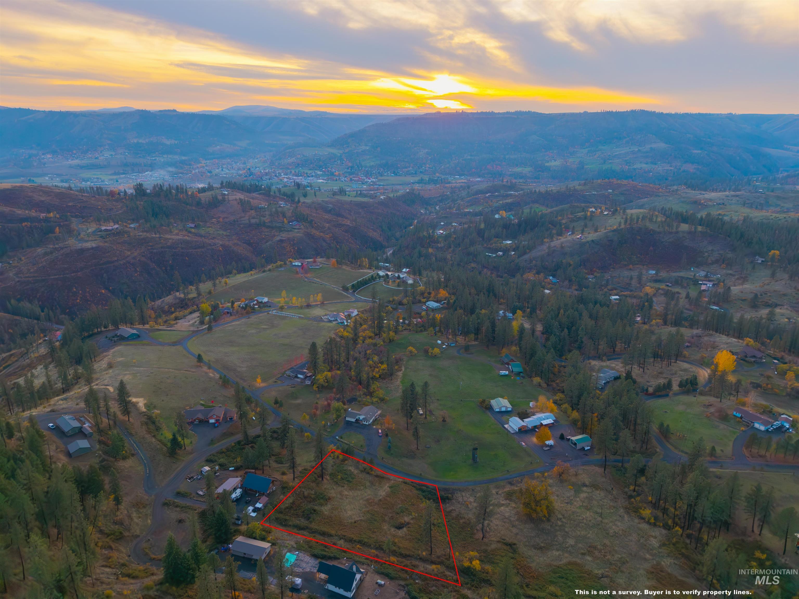 Aerial view of property's location with a mountainous background and property parcel outlined