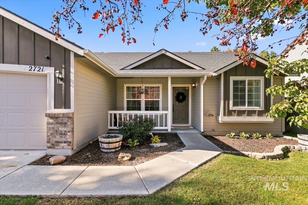 Entrance to property featuring board and batten siding, covered porch, a shingled roof, and a garage