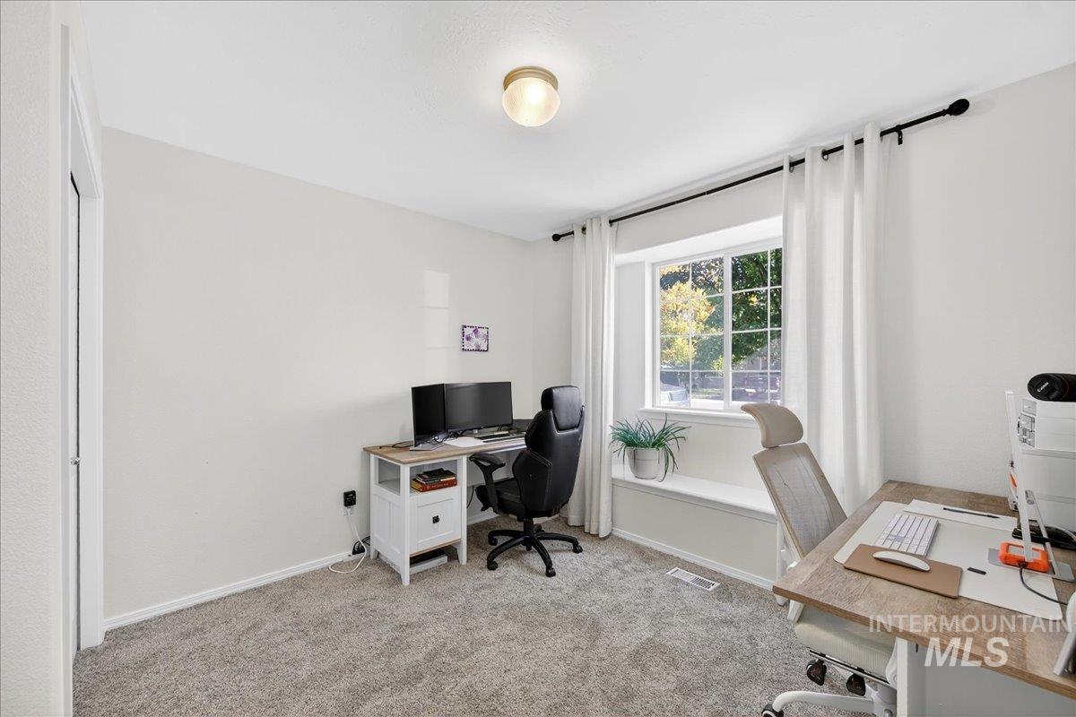 Office space with light carpet and baseboards