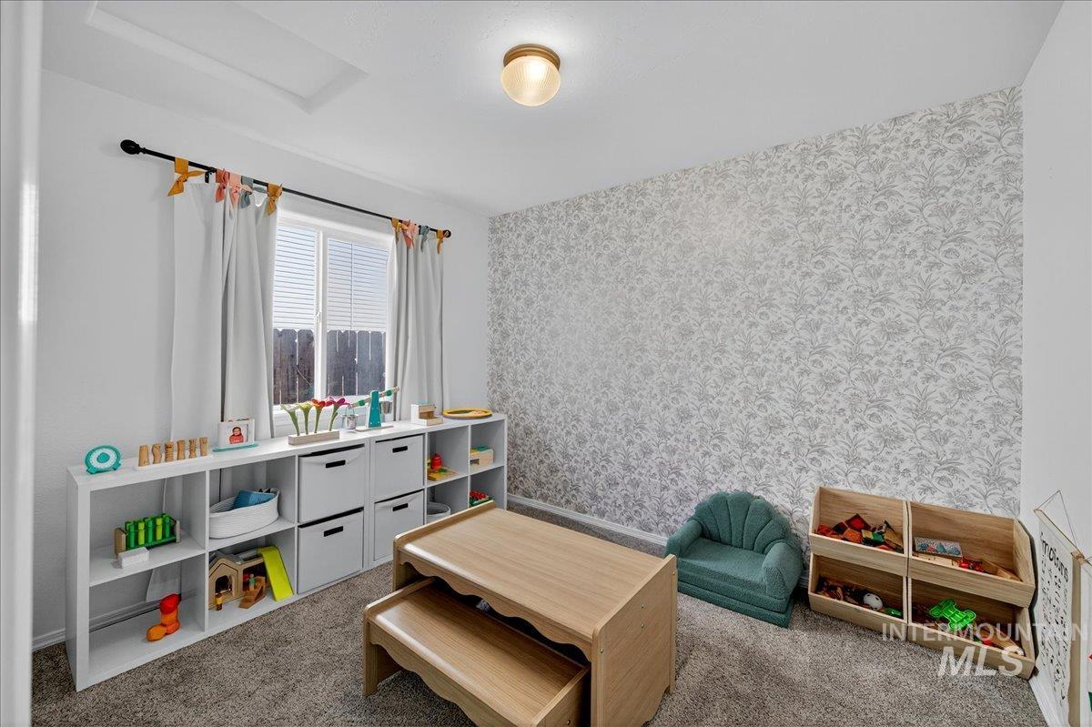 Recreation room featuring wallpapered walls, light colored carpet, and attic access