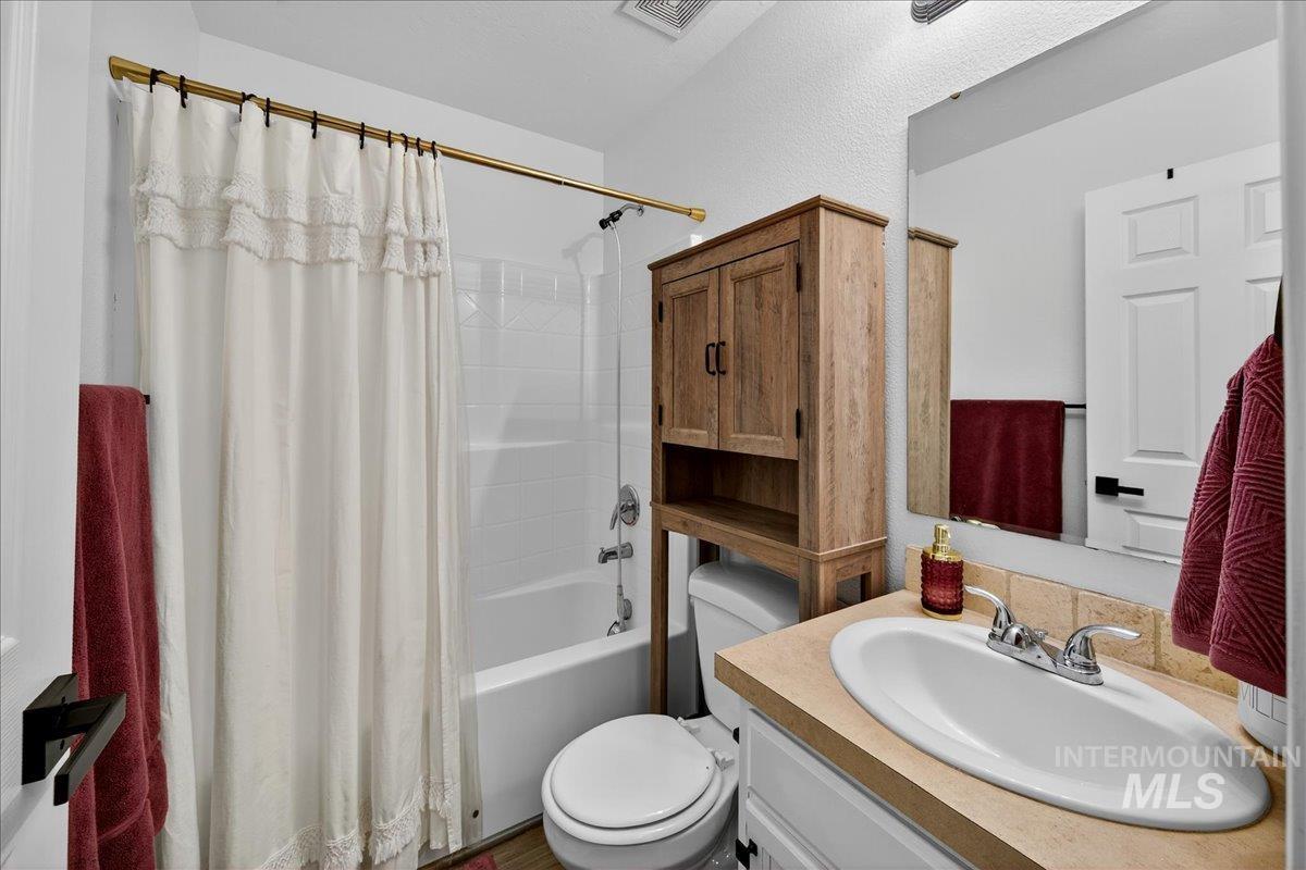 Bathroom with vanity and shower / bathtub combination with curtain