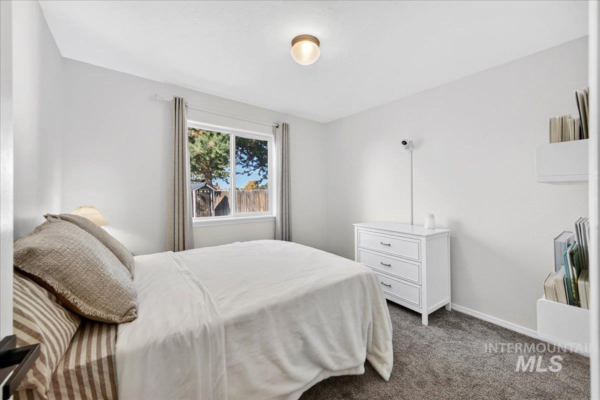 Bedroom with dark carpet and baseboards