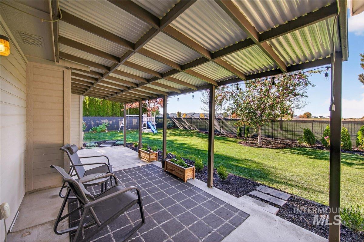 Fenced backyard with a patio and a playground